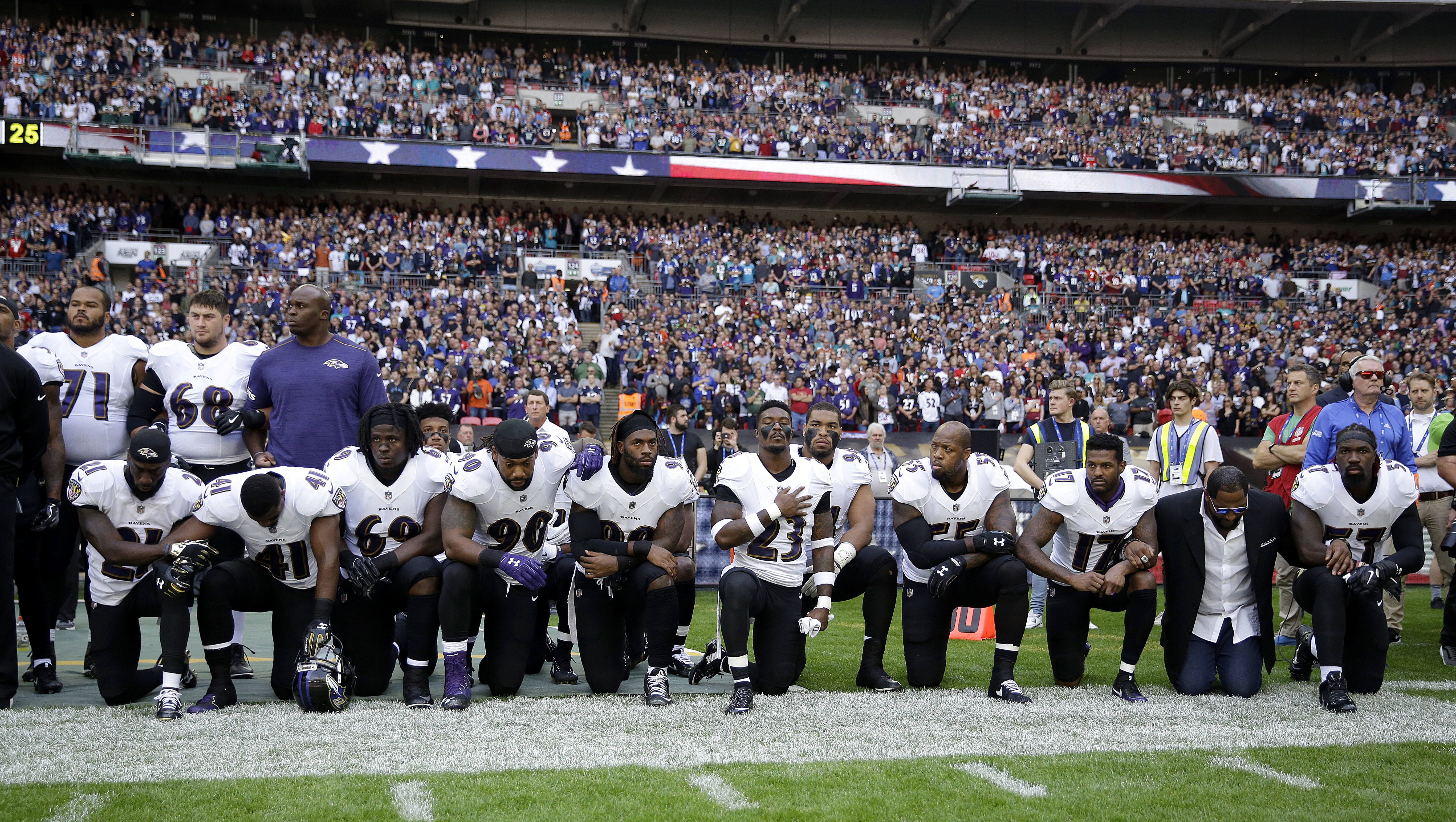 Baltimore Ravens players, including former player Ray Lewis, second from right, kneel down during the playing of the U.S. national anthem before an NFL football game against the Jacksonville Jaguars at Wembley Stadium in London, Sunday Sept. 24, 2017. (AP Photo/Matt Dunham)