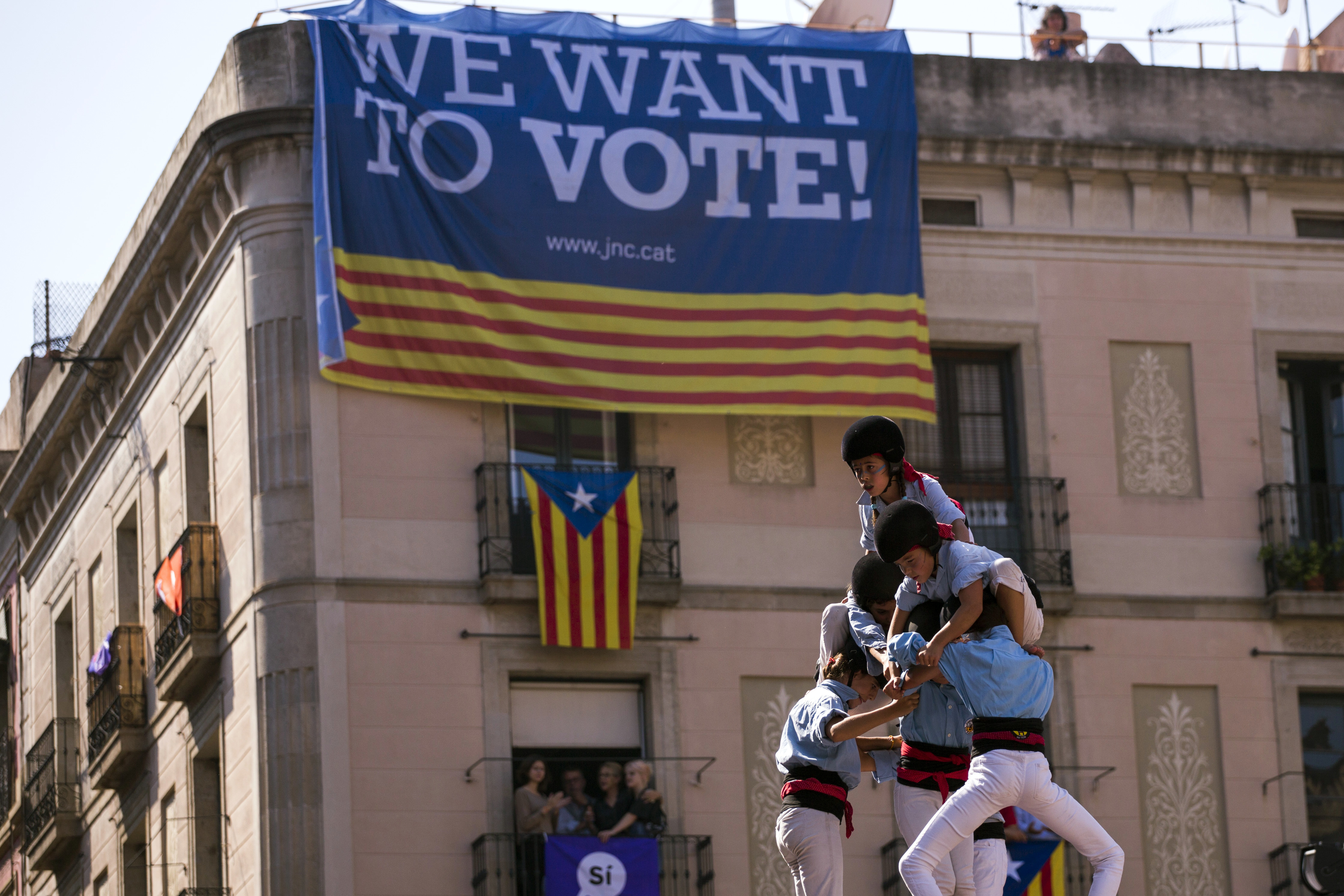 Members of a casteller form a human tower or "castell" in Sant Jaume square in Barcelona, Spain, over the weekend. (CREDIT: AP PHOTO / EMILIO MORENATTI)