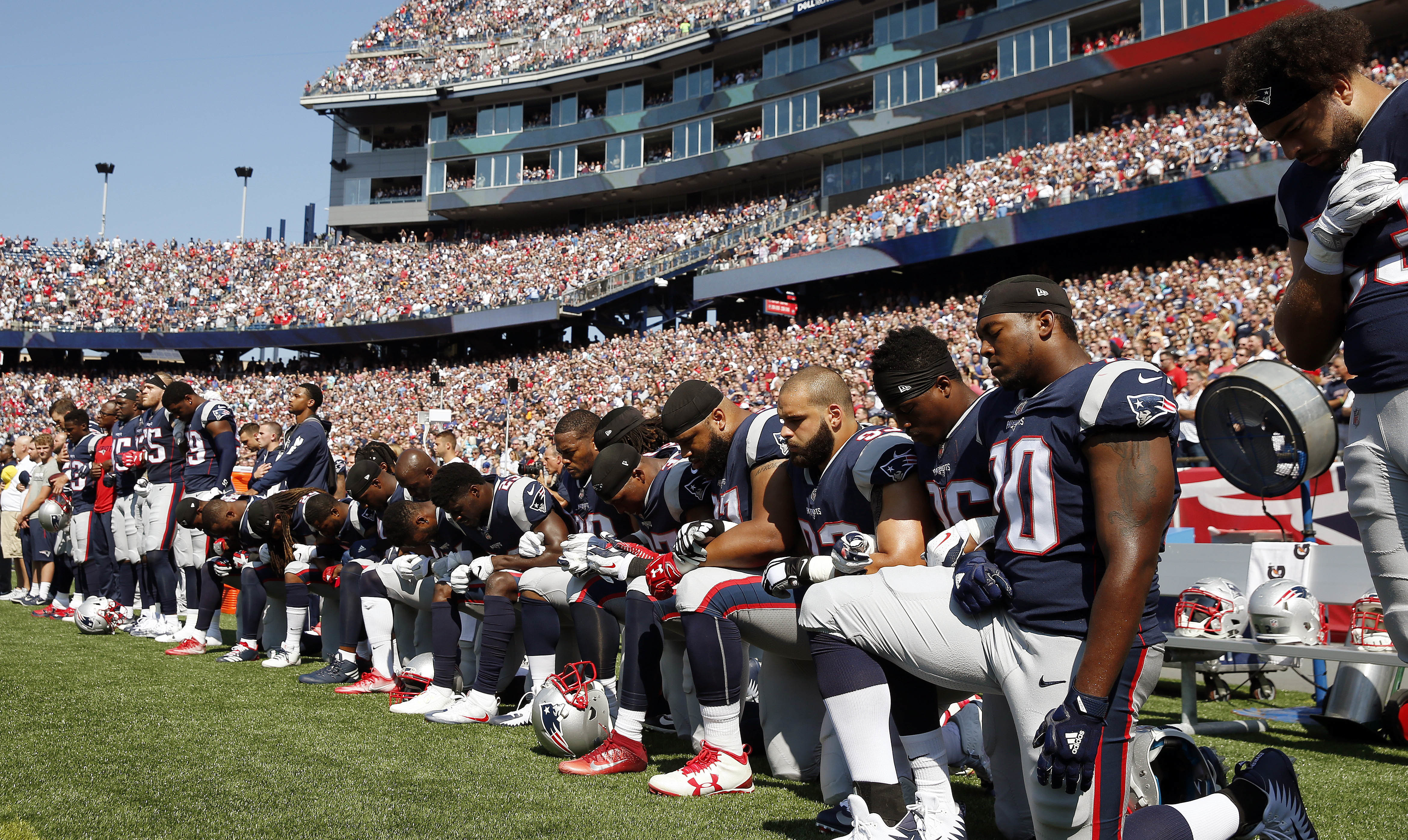 Several New England Patriots players kneel during the National Anthem, Sept. 24, 2017. CREDIT: AP Photo/Michael Dwyer
