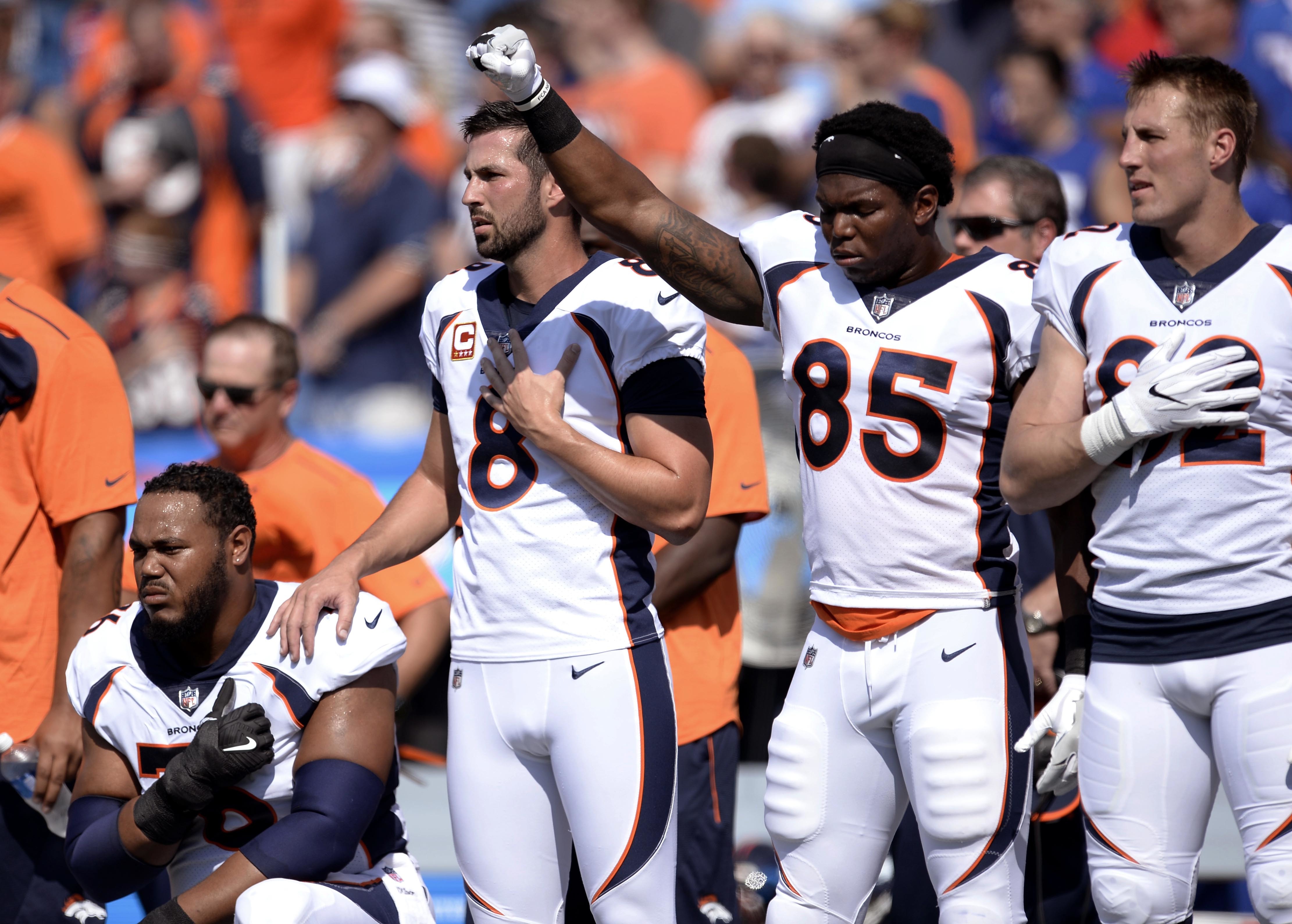 Denver Broncos tight end Virgil Green (85) gestures as teammate Max Garcia, left, takes a knee during the playing of the national anthem prior to an NFL football game against the Buffalo Bills, Sunday, Sept. 24, 2017, in Orchard Park, N.Y. (AP Photo/Adrian Kraus)