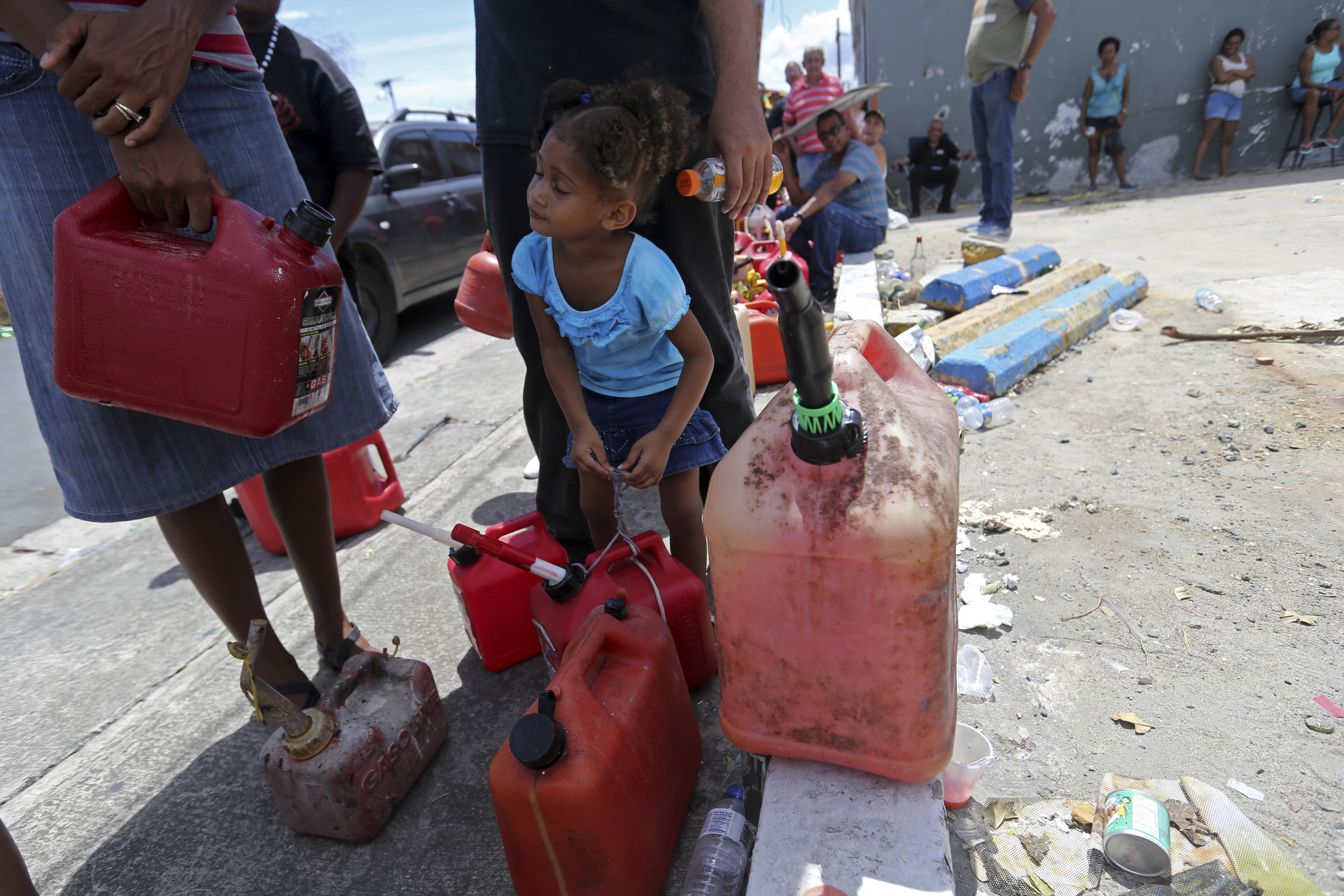 Abi de la Paz de la Cruz, 3, holds a gas can as she waits in line with her family, to get fuel from a gas station, in the aftermath of Hurricane Maria, in San Juan, Puerto Rico, Monday, Sept. 25, 2017. CREDIT: AP Photo/Gerald Herbert