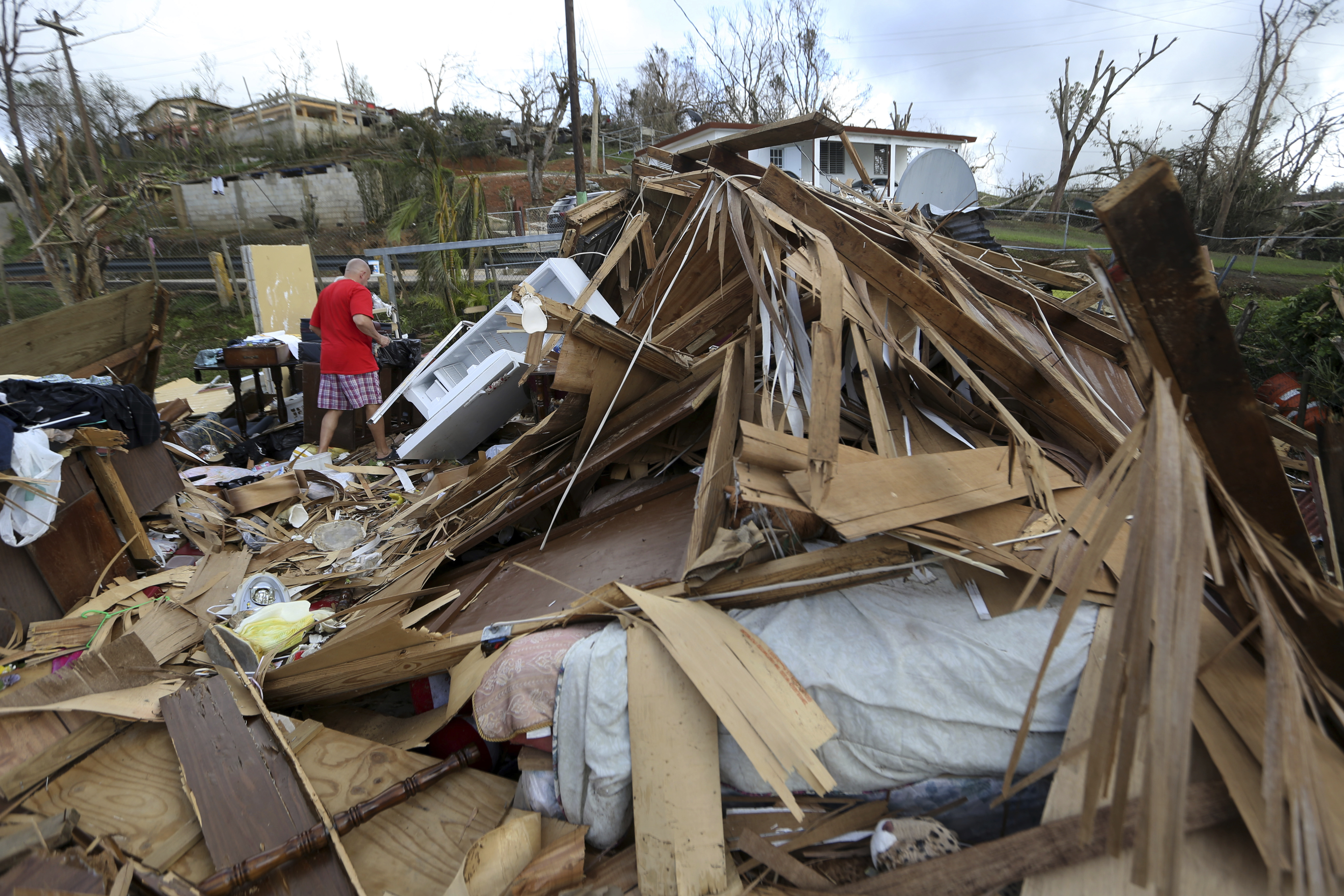 Jose Garcia Vicente walks through rubble of his destroyed home, in the aftermath of Hurricane Maria, in Aibonito, Puerto Rico, Monday, Sept. 25, 2017. CREDIT: AP Photo/Gerald Herbert