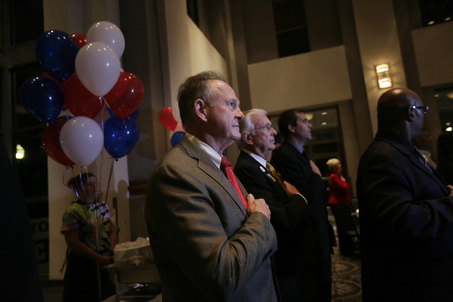 Roy Moore stops to say the Pledge of Allegiance as he walks around greeting supporters before his election party on Tuesday in Montgomery, Alabama. (CREDIT: AP Photo/Brynn Anderson)