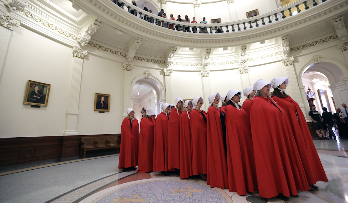Activists dressed as characters from "The Handmaid's Tale" chant in the Texas Capitol Rotunda as they protest CREDIT: SB8. AP/Eric Gay