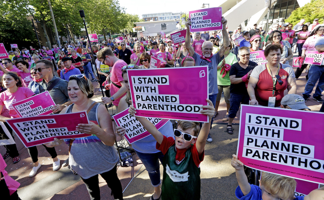 Seattle Storm fans and others cheer at a rally in support of Planned Parenthood before a WNBA basketball game between the Storm and the Chicago Sky on Tuesday, July 18, 2017, in Seattle. CREDIT: AP/Elaine Thompson)
