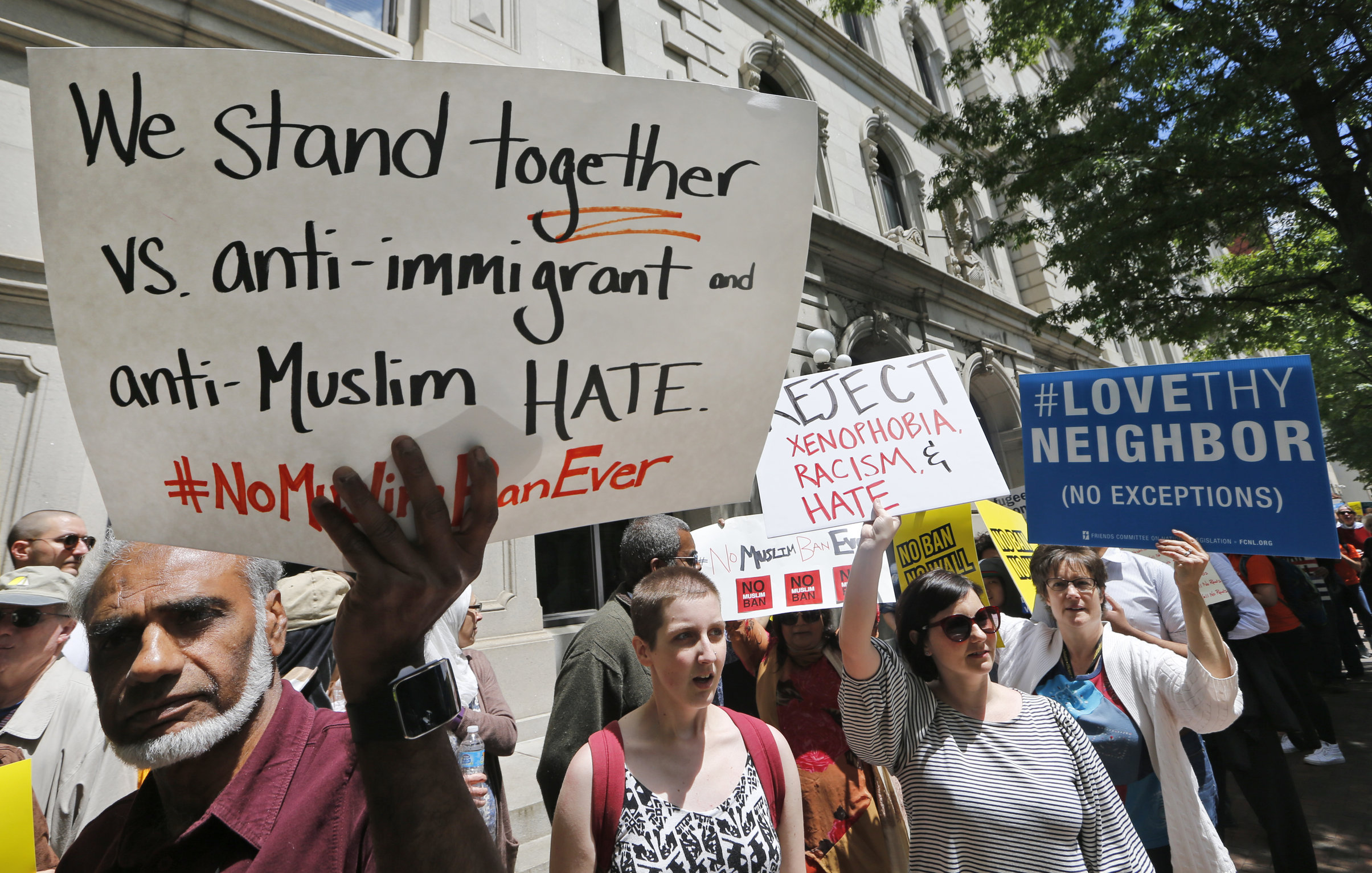 Protesters hold signs and march outside the US 4th Circuit Court of Appeals in Richmond, Va., Monday, May 8, 2017. (AP Photo/Steve Helber)