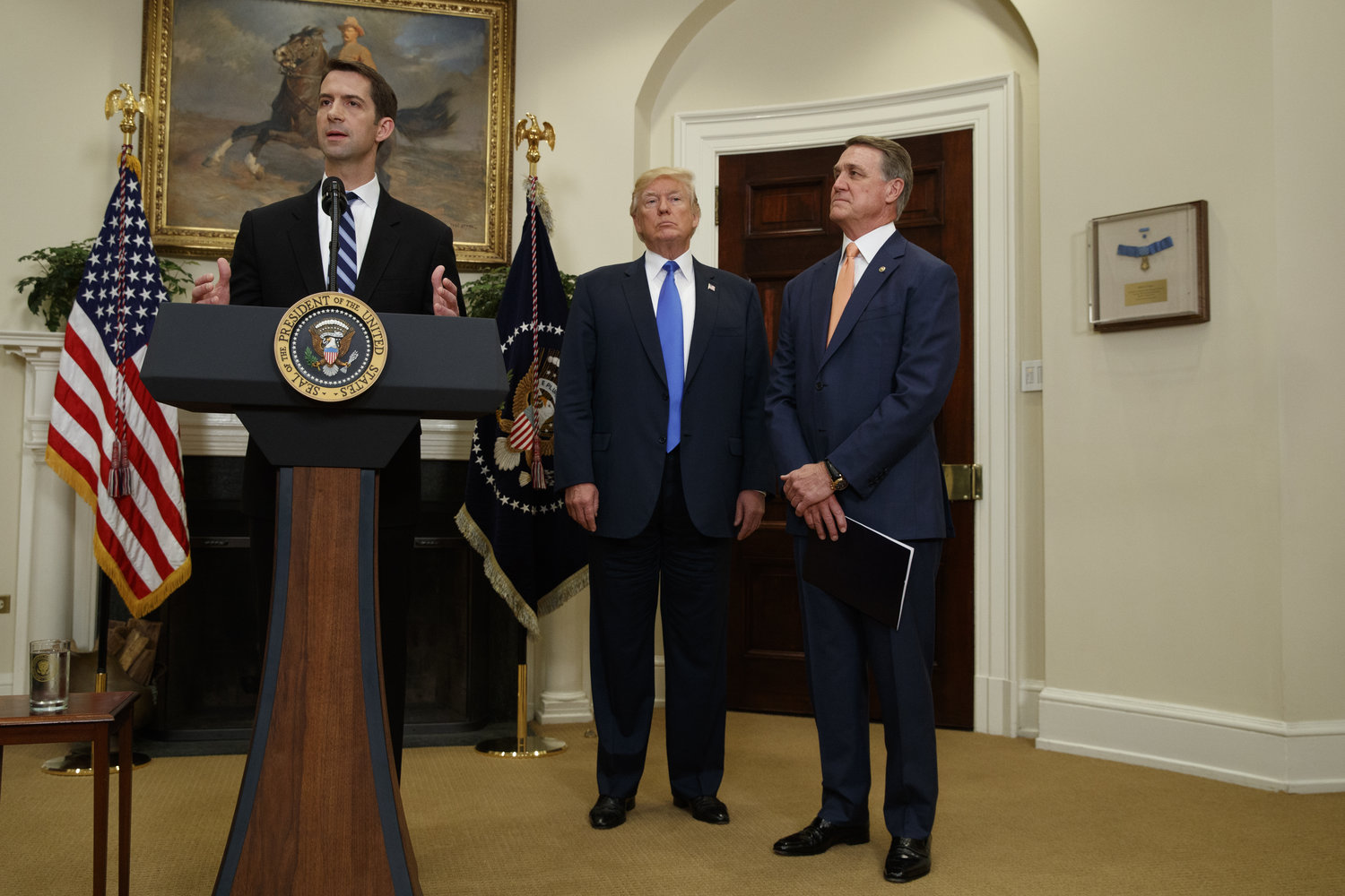 President Donald Trump, center, and Sen. David Perdue, R-Ga., right, listen as Sen. Tom Cotton, R- Ark. speaks in the Roosevelt Room of the White House in Washington, Wednesday, Aug. 2, 2017, during the unveiling of legislation that would place new limits on legal immigration. (AP Photo/Evan Vucci)