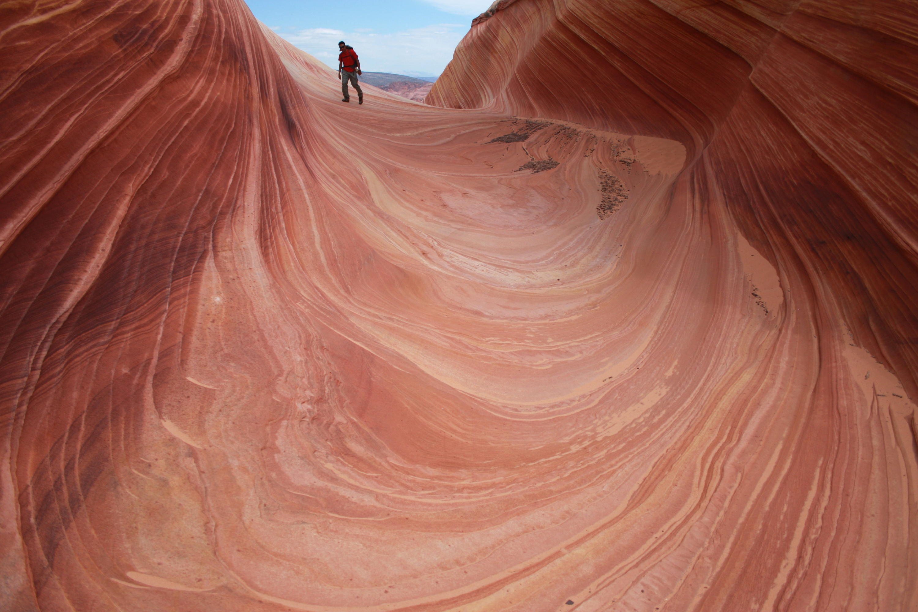 A hiker walks on a rock formation known as The Wave in the Vermilion Cliffs National Monument in Arizona. CREDIT: AP Photo/Brian Witte