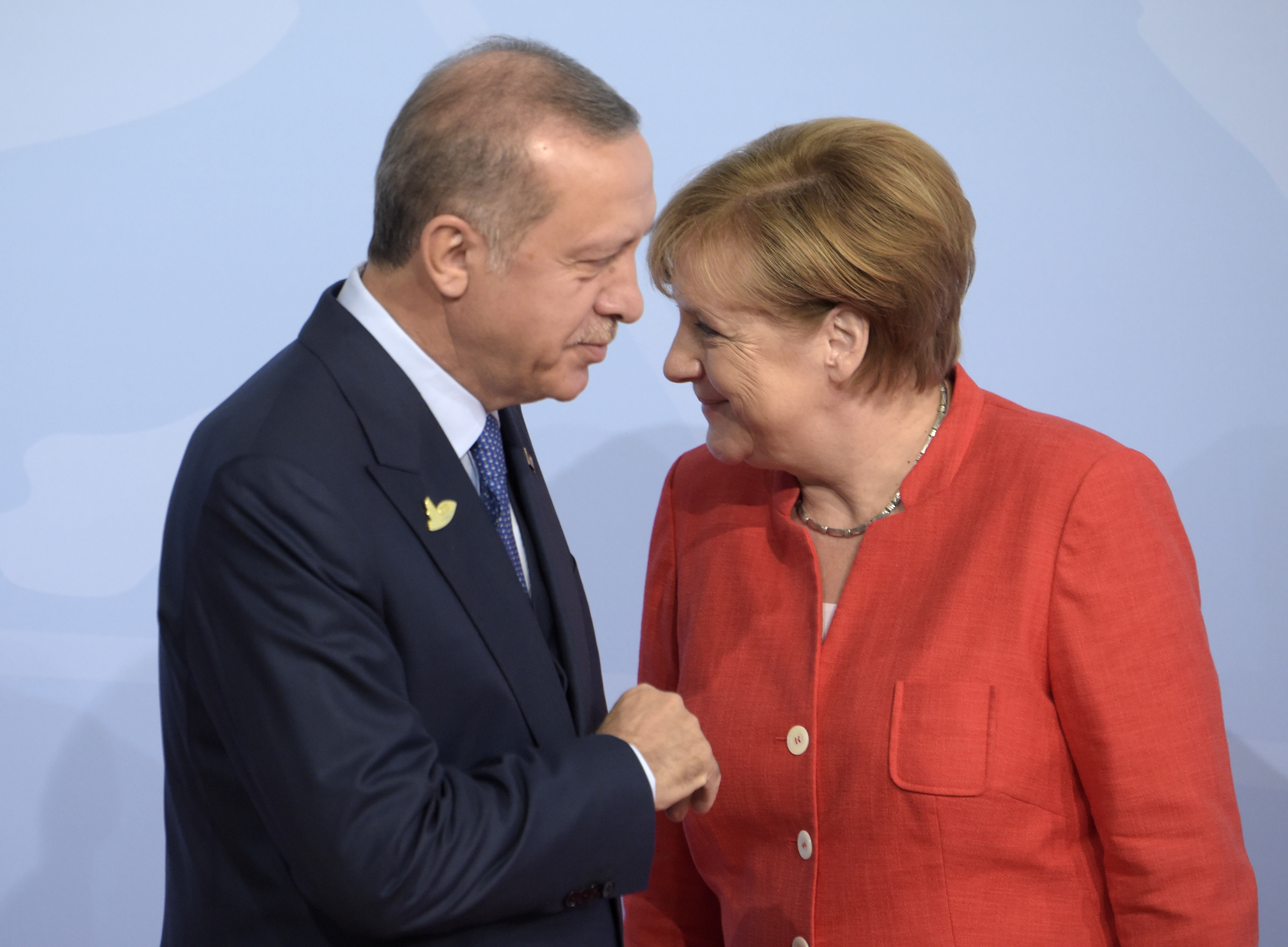 Turkish President Recep Tayyip Erdogan, left, is welcomed by German Chancellor Angela Merkel on the first day of the G-20 summit in Hamburg, northern Germany, July 7, 2017. (CREDIT: Jens Meyer/AP Photo)