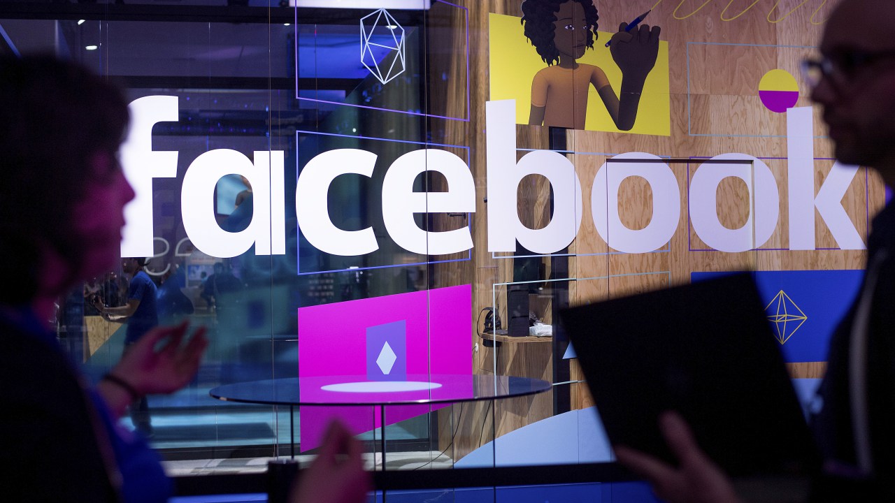 In this April 18, 2017, file photo, conference workers speak in front of a demo booth at Facebook's annual F8 developer conference, in San Jose, Calif. (CREDIT: AP Photo/Noah Berger, File)