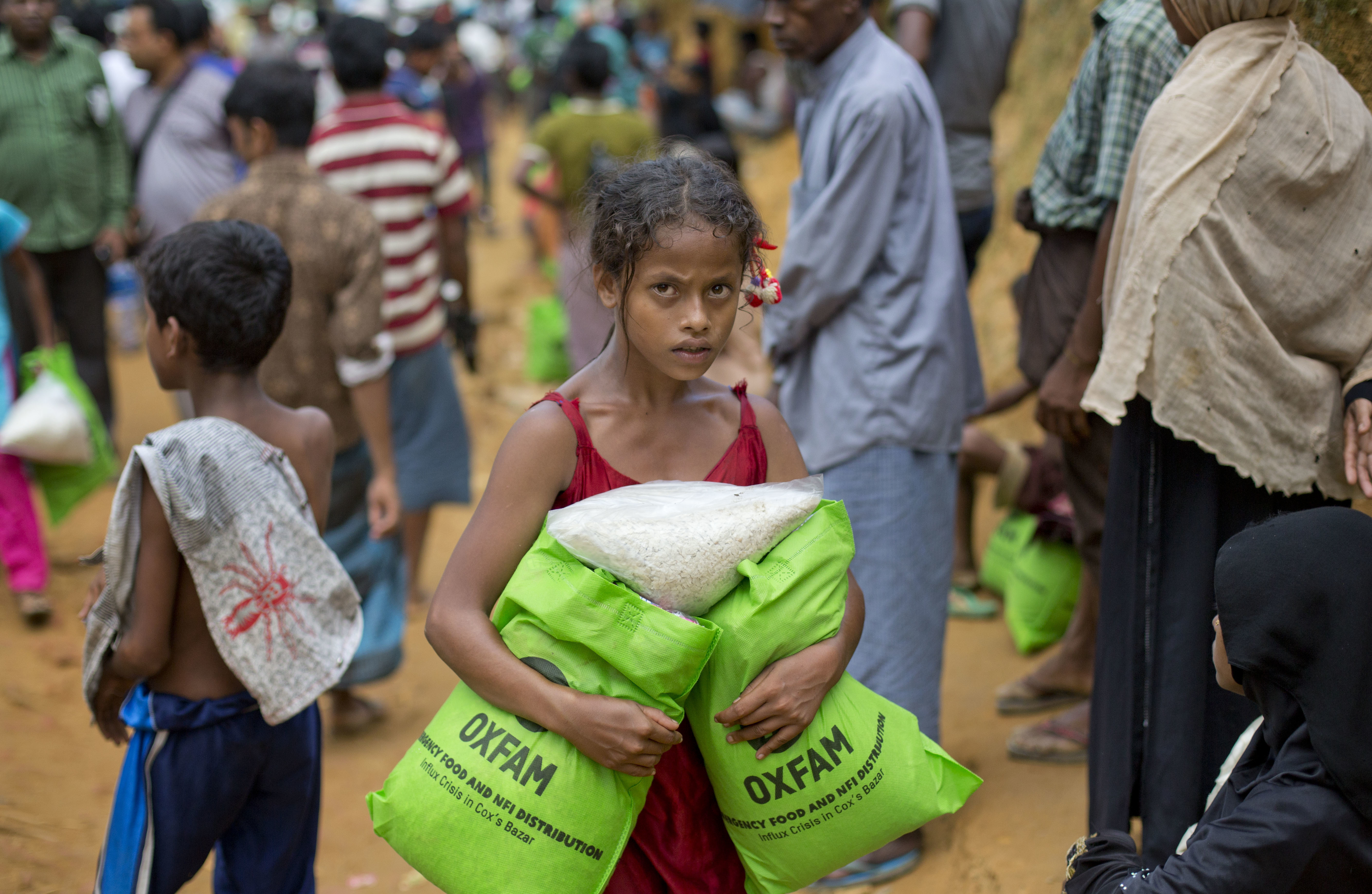 A newly arrived Rohingya girl carries food rations in Kutupalong, Bangladesh, Saturday, Sept. 30, 2017. CREDIT: Gemunu Amarasinghe/AP Photo