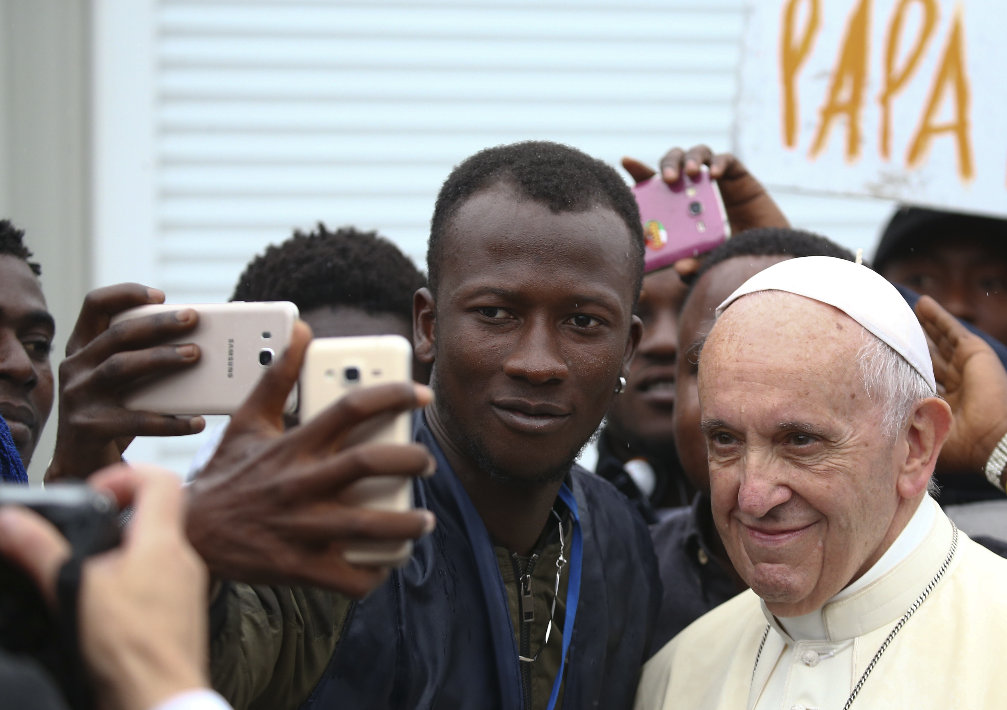 Pope Francis poses for selfies with migrants at a regional migrant center, in Bologna, Italy, Sunday, Oct. 1, 2017. (CREDIT: Alessandro Bianchi/ Pool photo via AP)