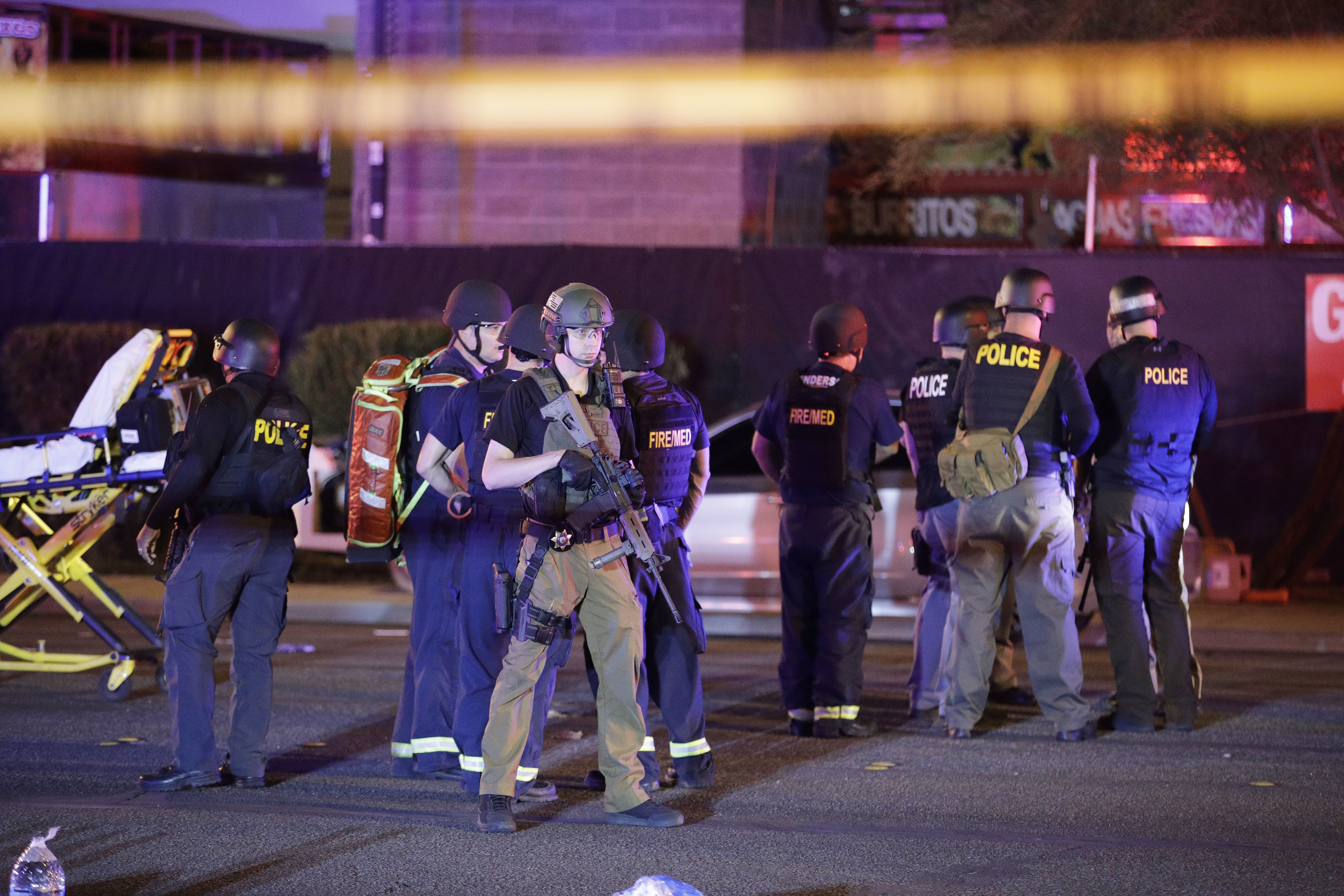 Police officers and medical personnel stand at the scene of a shooting near the Mandalay Bay resort and casino on the Las Vegas Strip, Monday, Oct. 2, 2017, in Las Vegas. CREDIT: AP Photo/John Locher