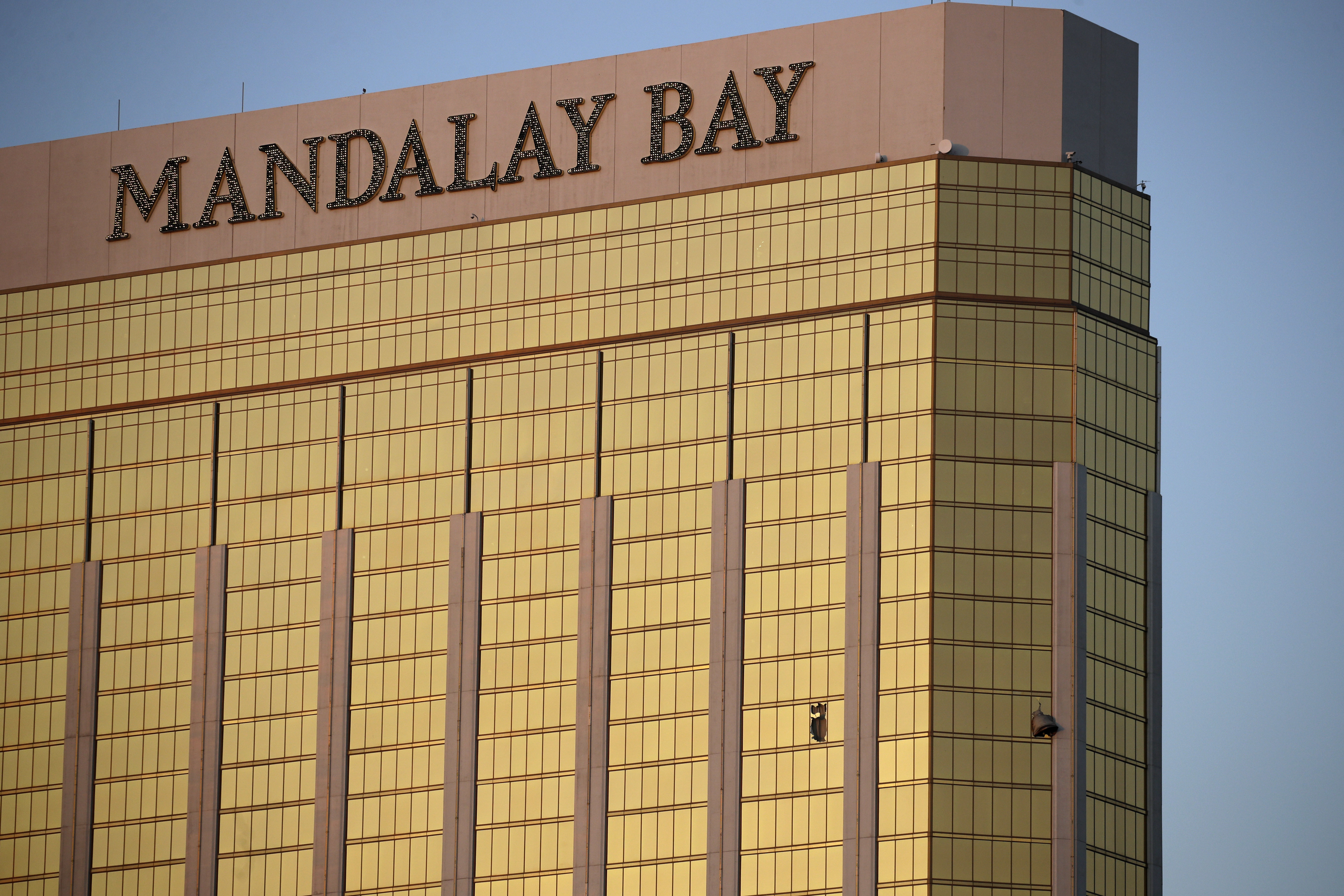 Drapes billow out of broken windows at the Mandalay Bay resort and casino Monday, Oct. 2, 2017, on the Las Vegas Strip following a deadly shooting at a music festival in Las Vegas. A gunman was found dead inside a hotel room. CREDIT: AP Photo/John Locher
