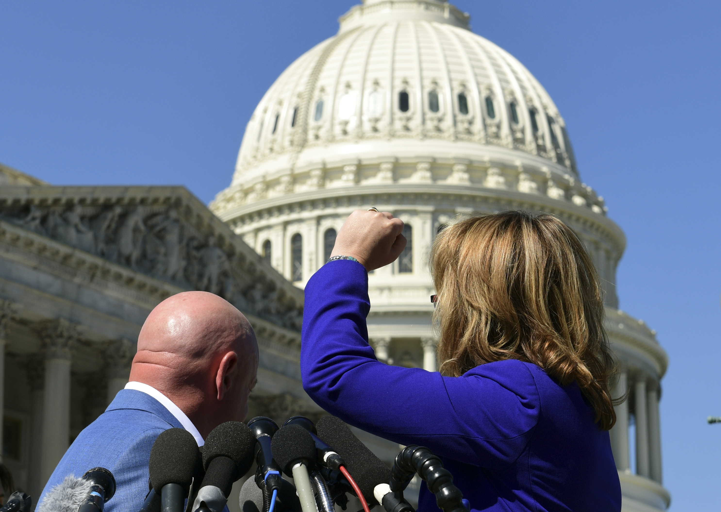 Former Rep. Gabrielle Giffords, D-Ariz., right, shakes her fist at the United States Capitol as she and her husband Mark Kelly, left, speak on Capitol Hill in Washington, Monday, Oct. 2, 2017, about the mass shooting in Las Vegas. Giffords raised her fist at the Capitol and said “the nation is counting on you” after the deadly mass shooting in Las Vegas. (AP Photo/Susan Walsh)