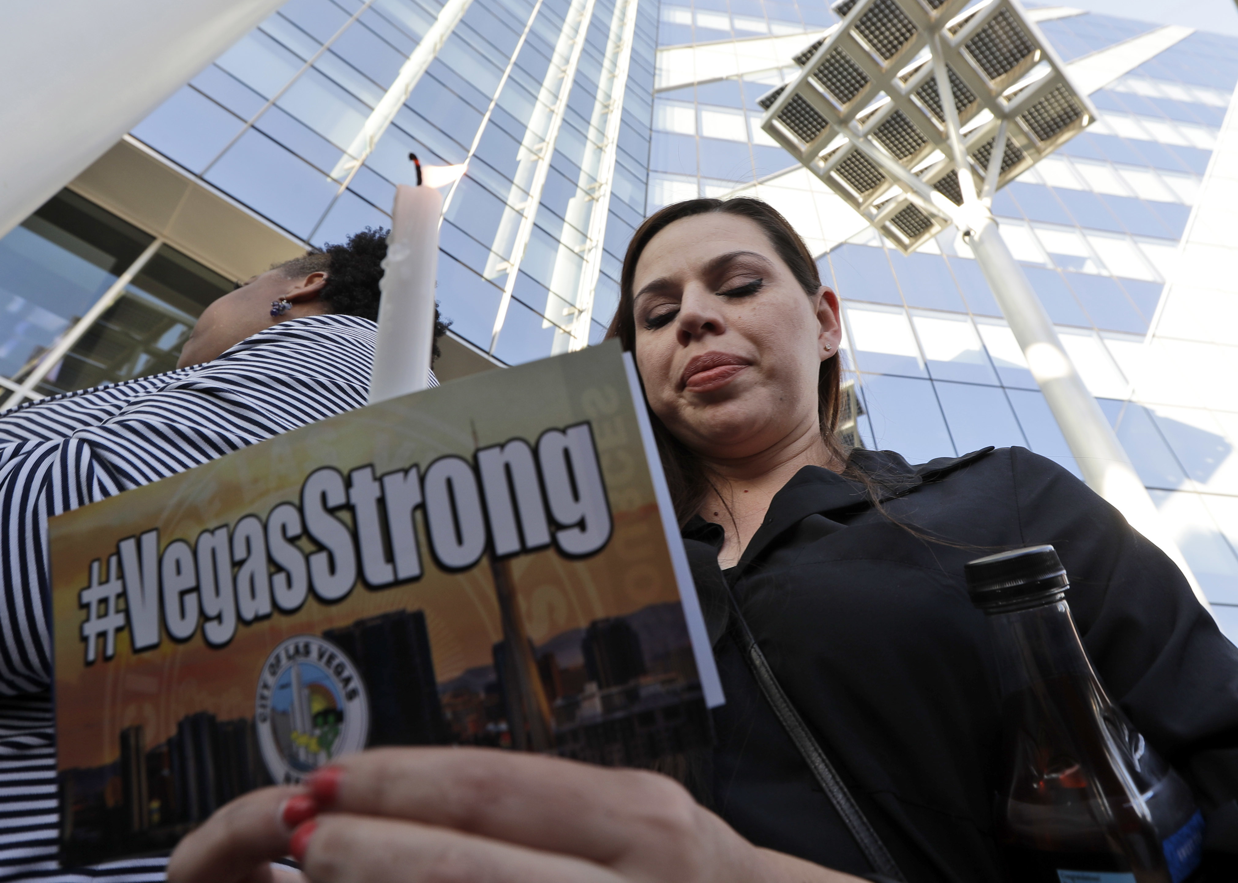 Kristin Alexander holds a candle during a vigil at City Hall in Las Vegas, Monday, Oct. 2, 2017. The vigil was held in honor of the over 50 people killed and hundreds injured in a mass shooting at an outdoor music concert late Sunday. CREDIT: AP Photo/Gregory Bull