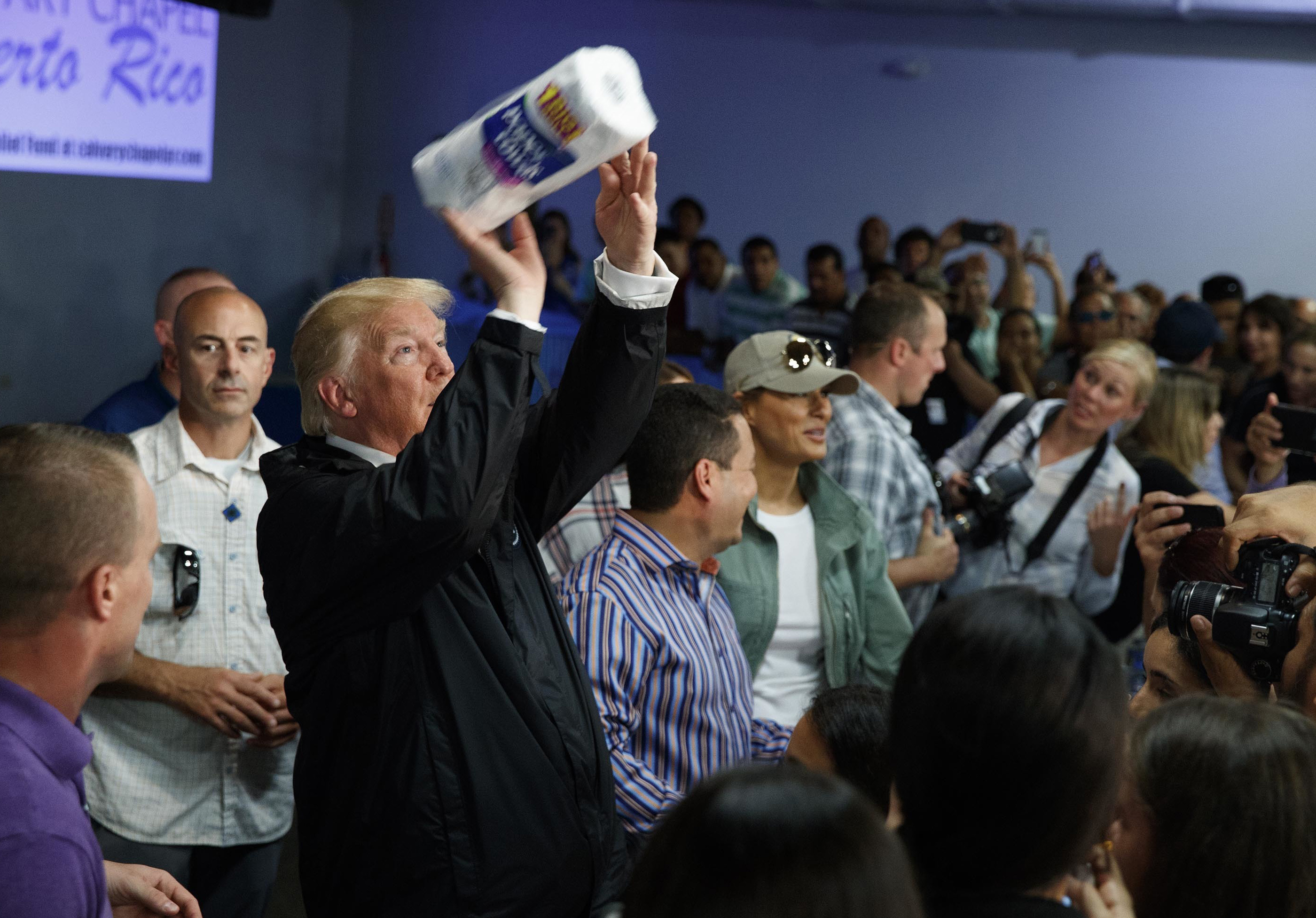 President Donald Trump tosses paper towels into a crowd as he hands out supplies at Calvary Chapel, Tuesday, Oct. 3, 2017, in Guaynabo, Puerto Rico. CREDIT: AP Photo/Evan Vucci