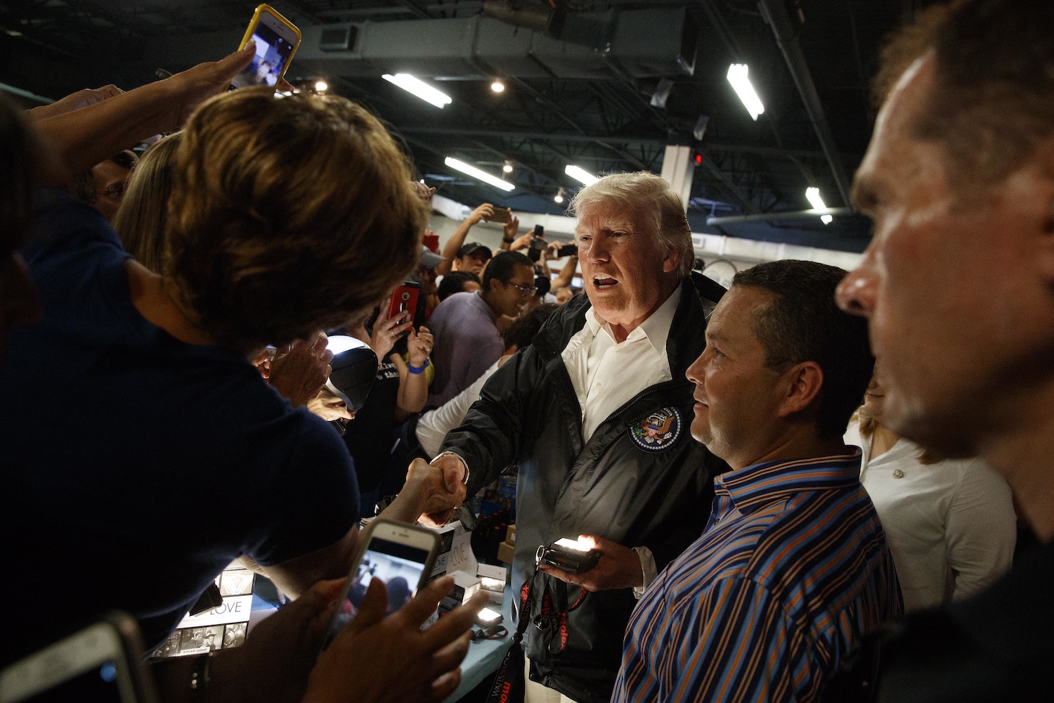 President Donald Trump says "Flashlights! You don't need 'em anymore" as he hands them out to Puerto Ricans, 93 percent of whom still lack power. October 3. CREDIT: AP/Evan Vucci