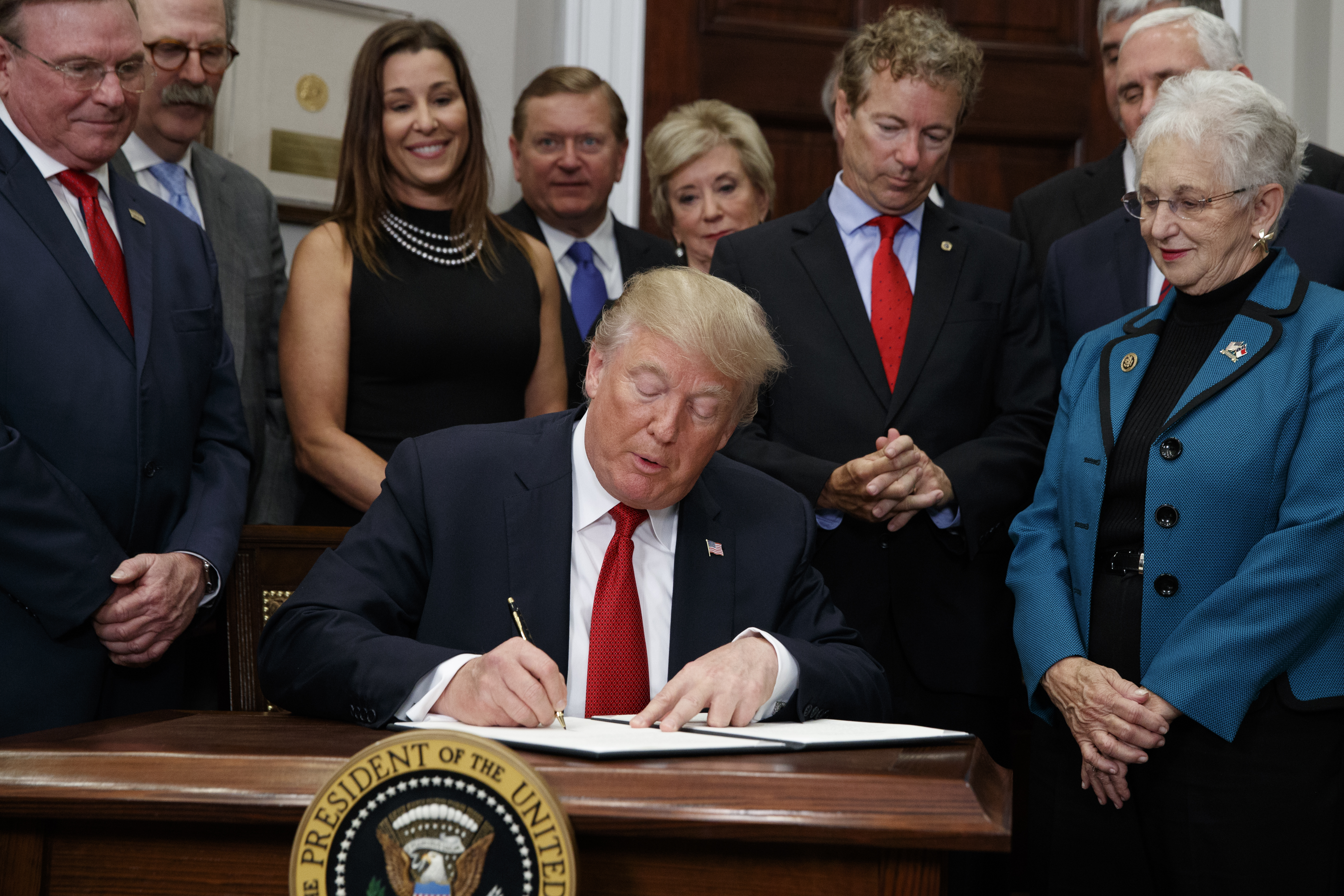 President Donald Trump signs an executive order on health care in the Roosevelt Room of the White House, Thursday, Oct. 12, 2017, in Washington. (AP Photo/Evan Vucci)