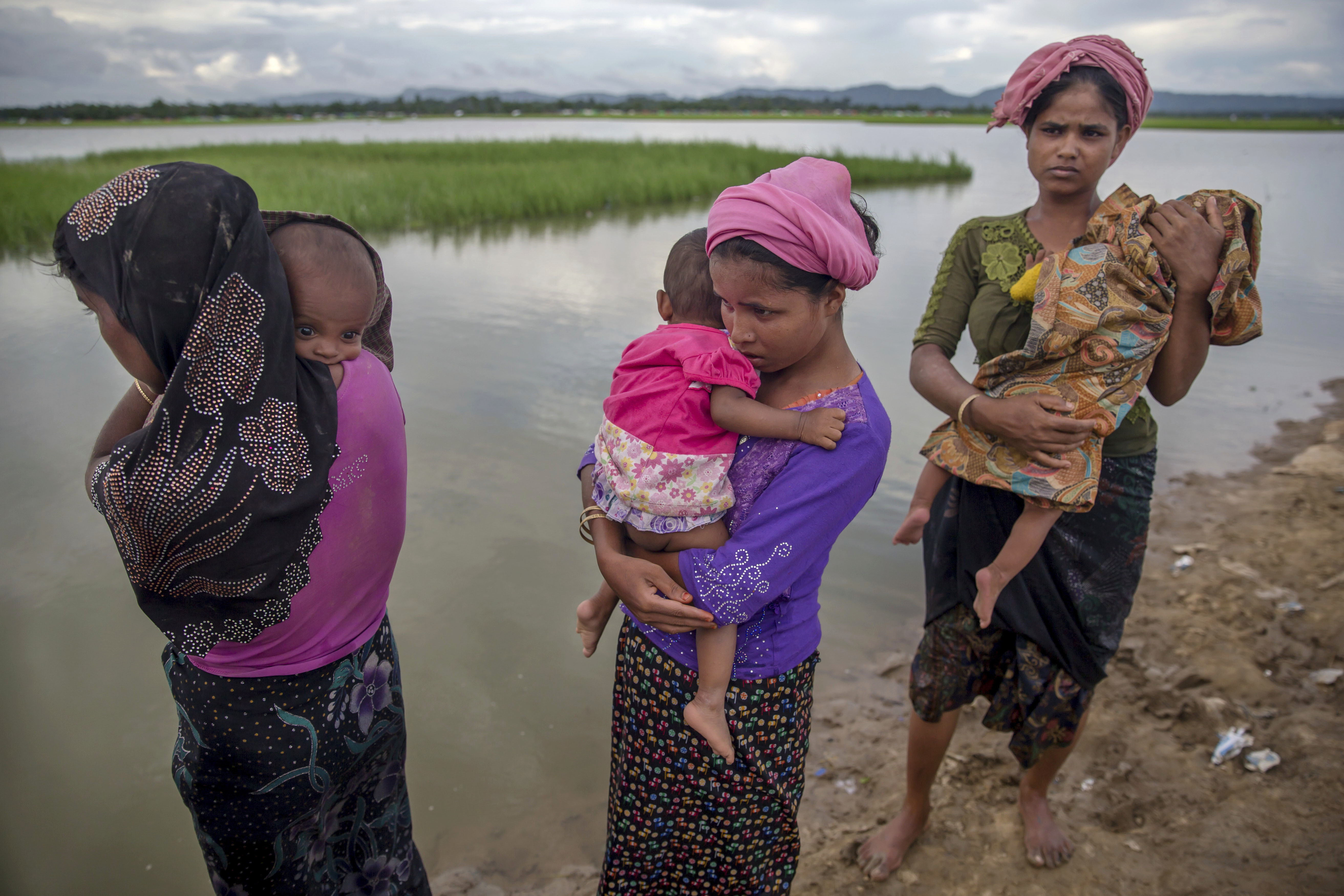 Rohingya Muslim women, who crossed over from Myanmar into Bangladesh, stand holding their sick children after Bangladesh border guard soldiers refused to let them journey towards a hospital and turned them back towards the zero line border in Palong Khali, Bangladesh, Wednesday, Oct. 18, 2017. CREDIT: Dar Yasin/ AP Photo.