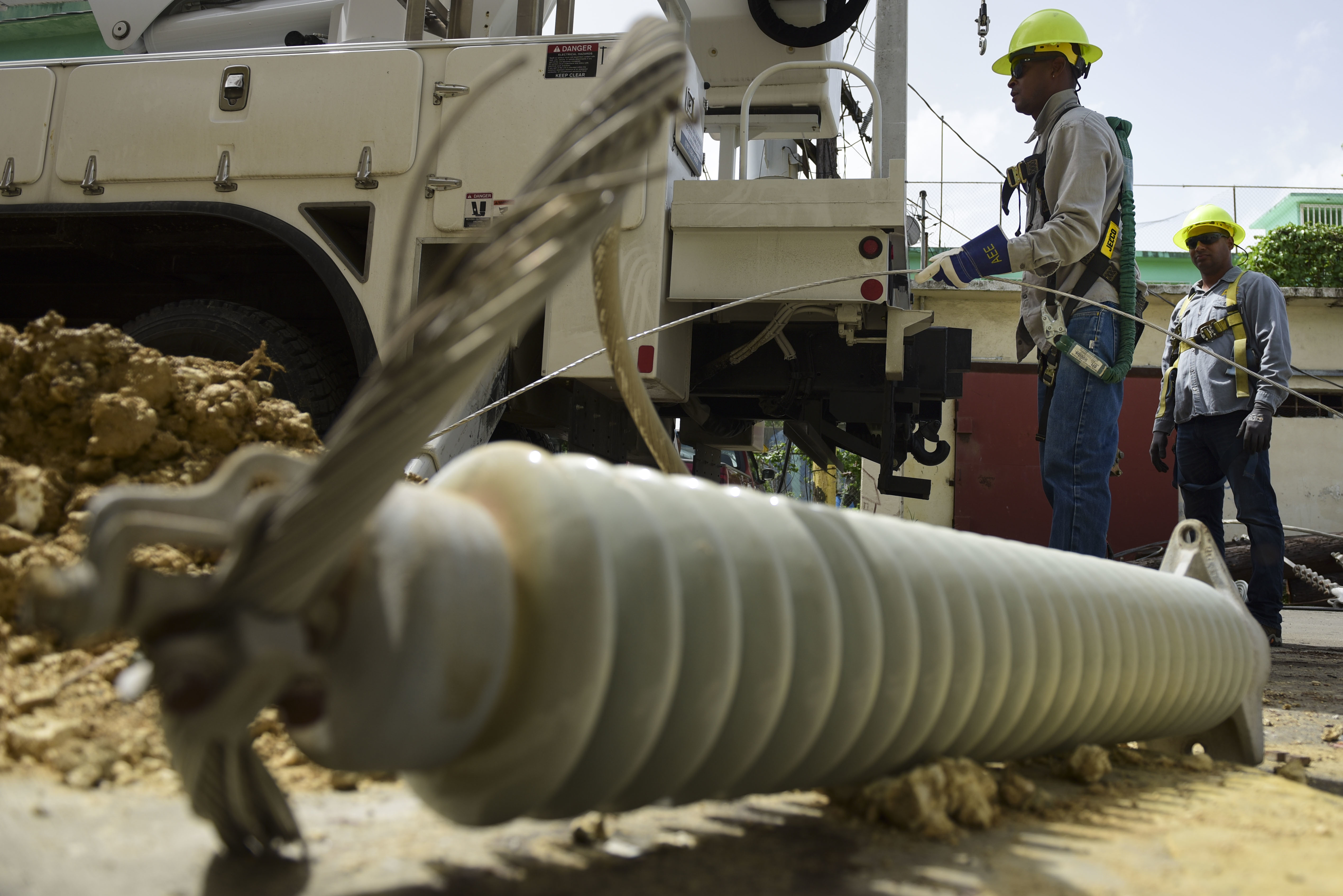 A brigade from the Electric Power Authority repairs distribution lines damaged by Hurricane Maria in the Cantera community of San Juan, Puerto Rico. (CREDIT: AP Photo/Carlos Giusti)