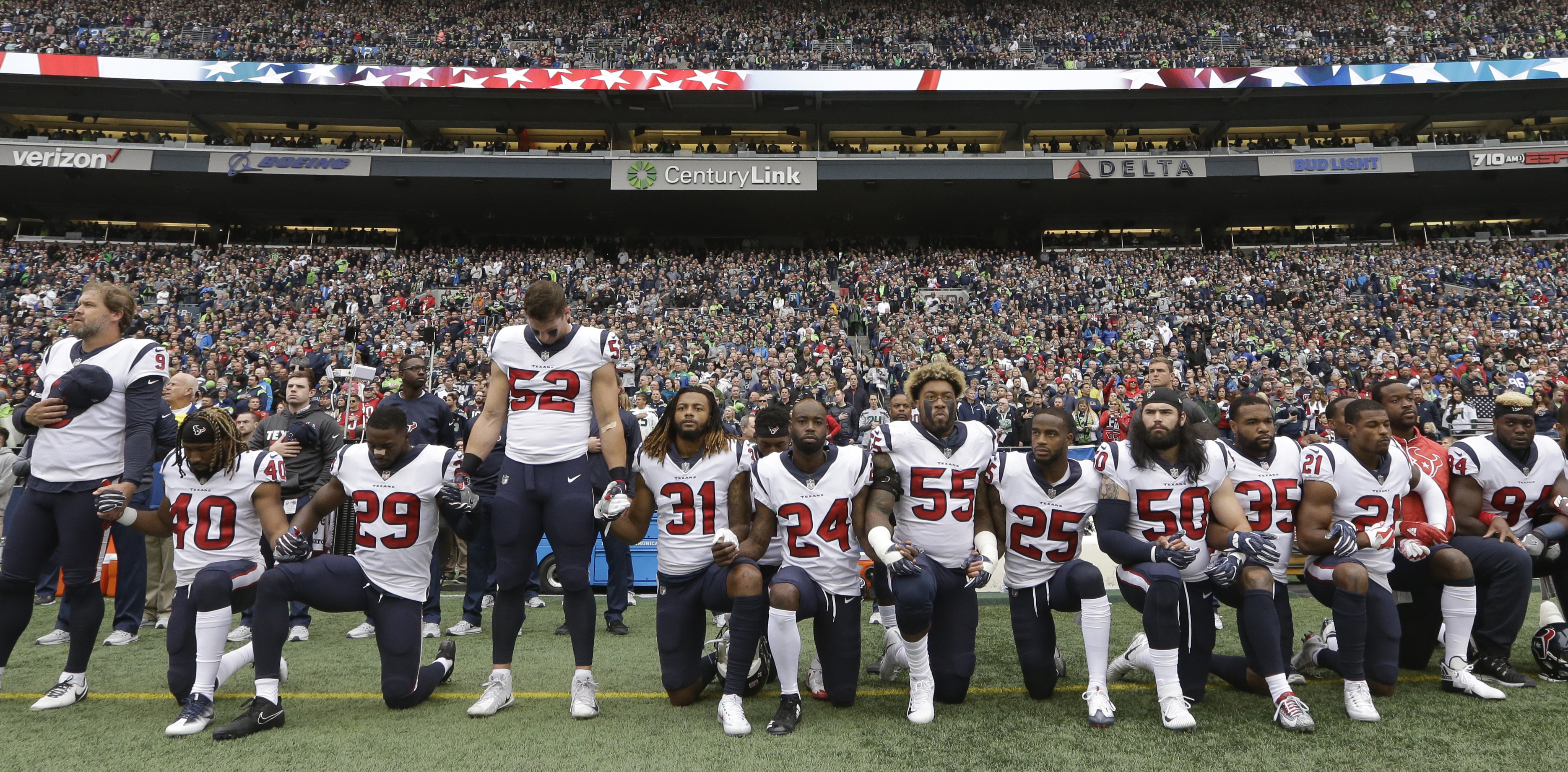 Houston Texans players kneel and stand during the singing of the national anthem before an NFL football game against the Seattle Seahawks, Sunday, Oct. 29, 2017, in Seattle. (AP Photo/Elaine Thompson)