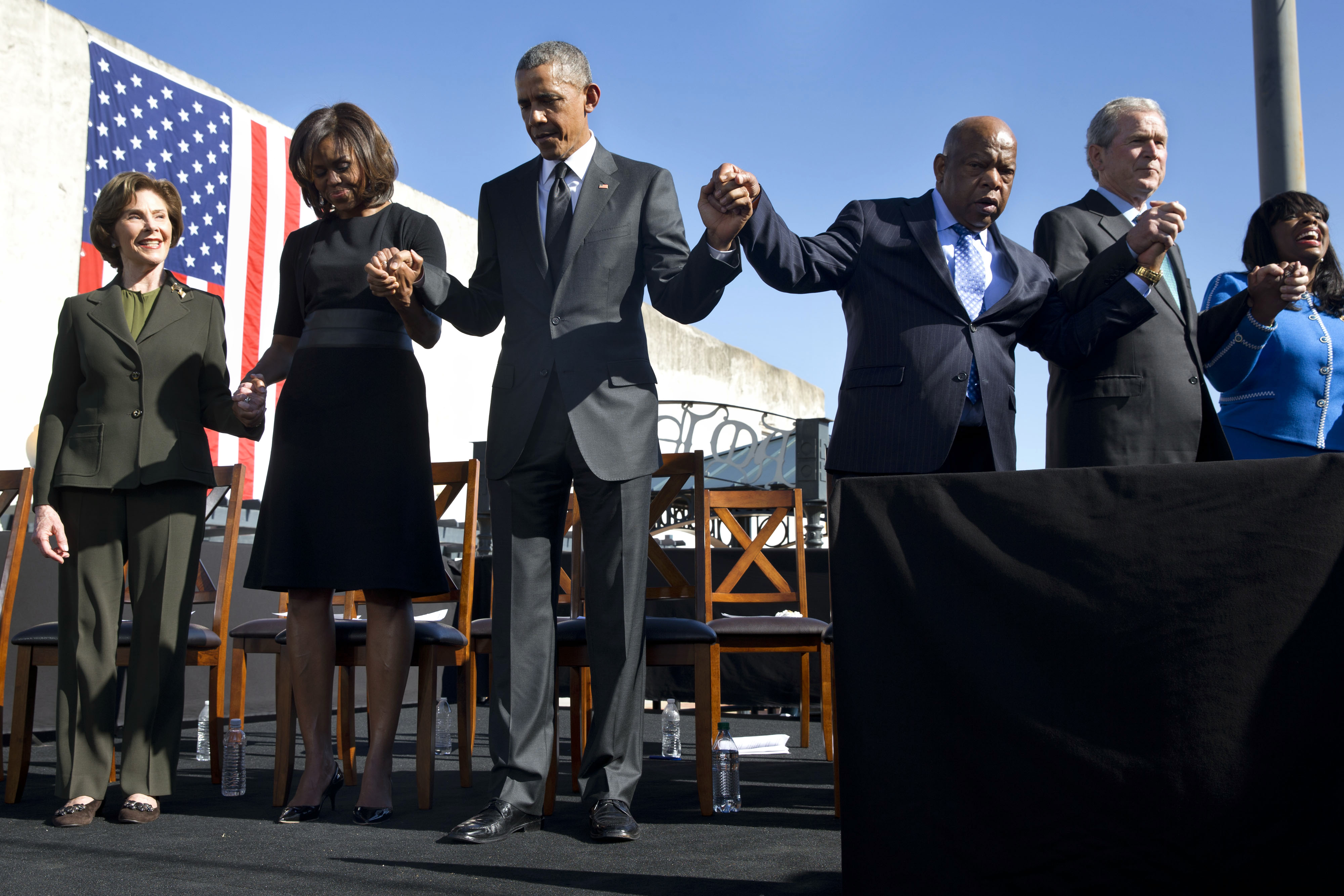 Barack Obama prays with Laura Bush, Michelle Obama, John Lewis, and George W. Bush in March 2015. CREDIT: AP Photo/Jacquelyn Martin