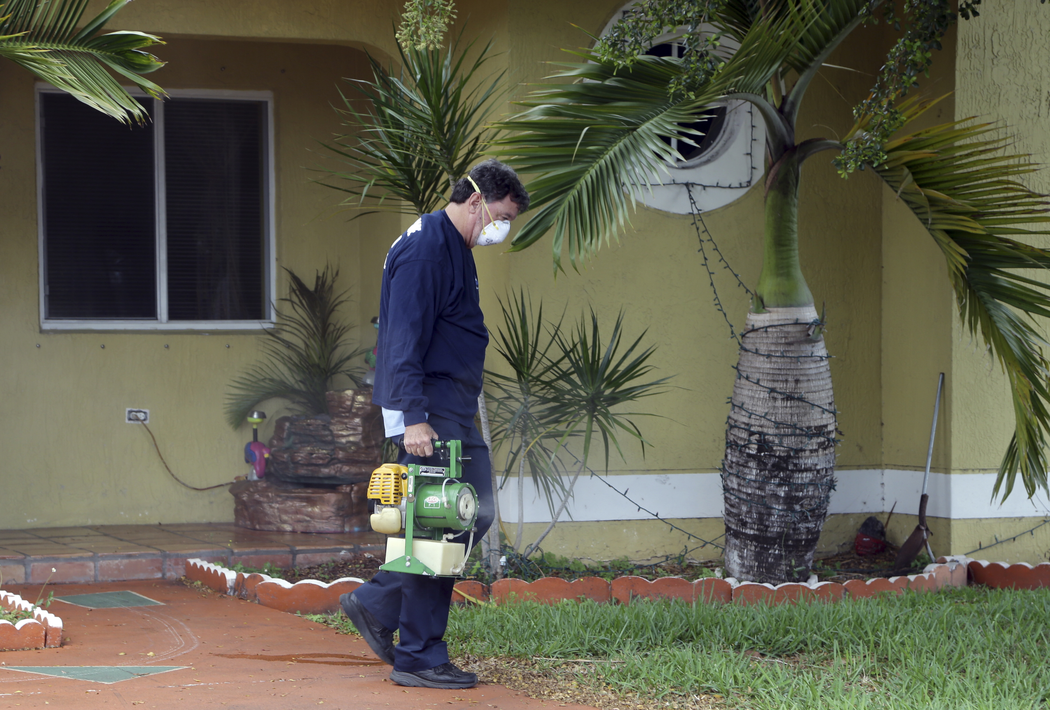Worker sprays pesticide near a fountain in Miami to curb the spread of the Zika virus. CREDIT: AP Photo/Lynne Sladky