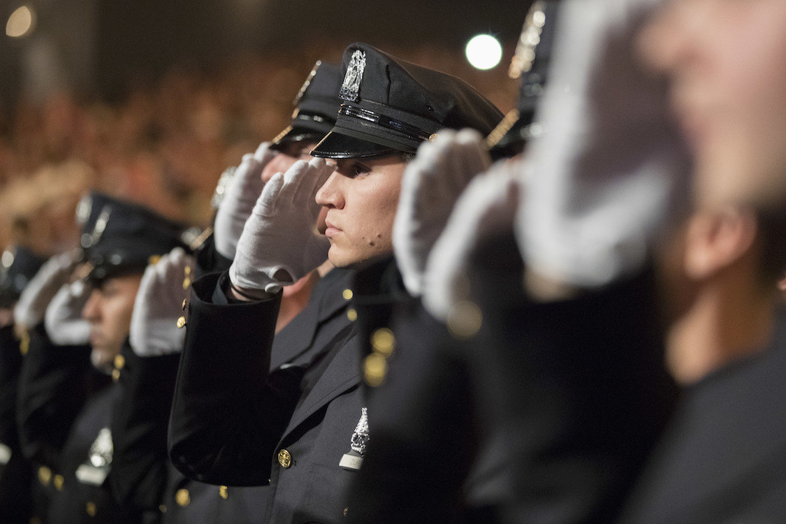The newest members of the New York City police salute during the Star Spangled Banner at their graduation ceremony, Thursday, June 29, 2017, in New York. CREDIT: AP/Mary Altaffer