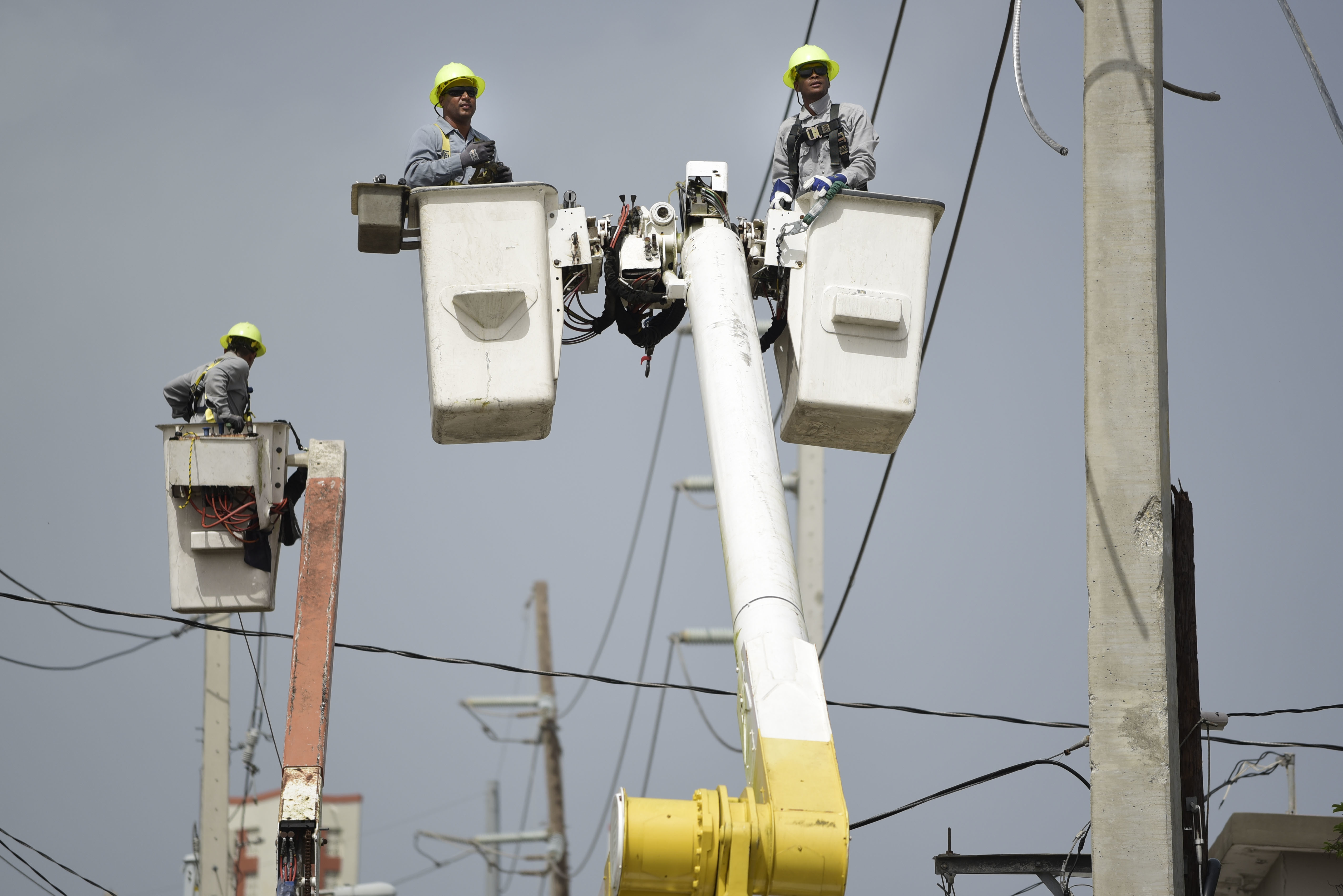A brigade from the Puerto Rico Electric Power Authority repairs distribution lines damaged by Hurricane Maria in San Juan, Puerto Rico. CREDIT: AP Photo/Carlos Giusti