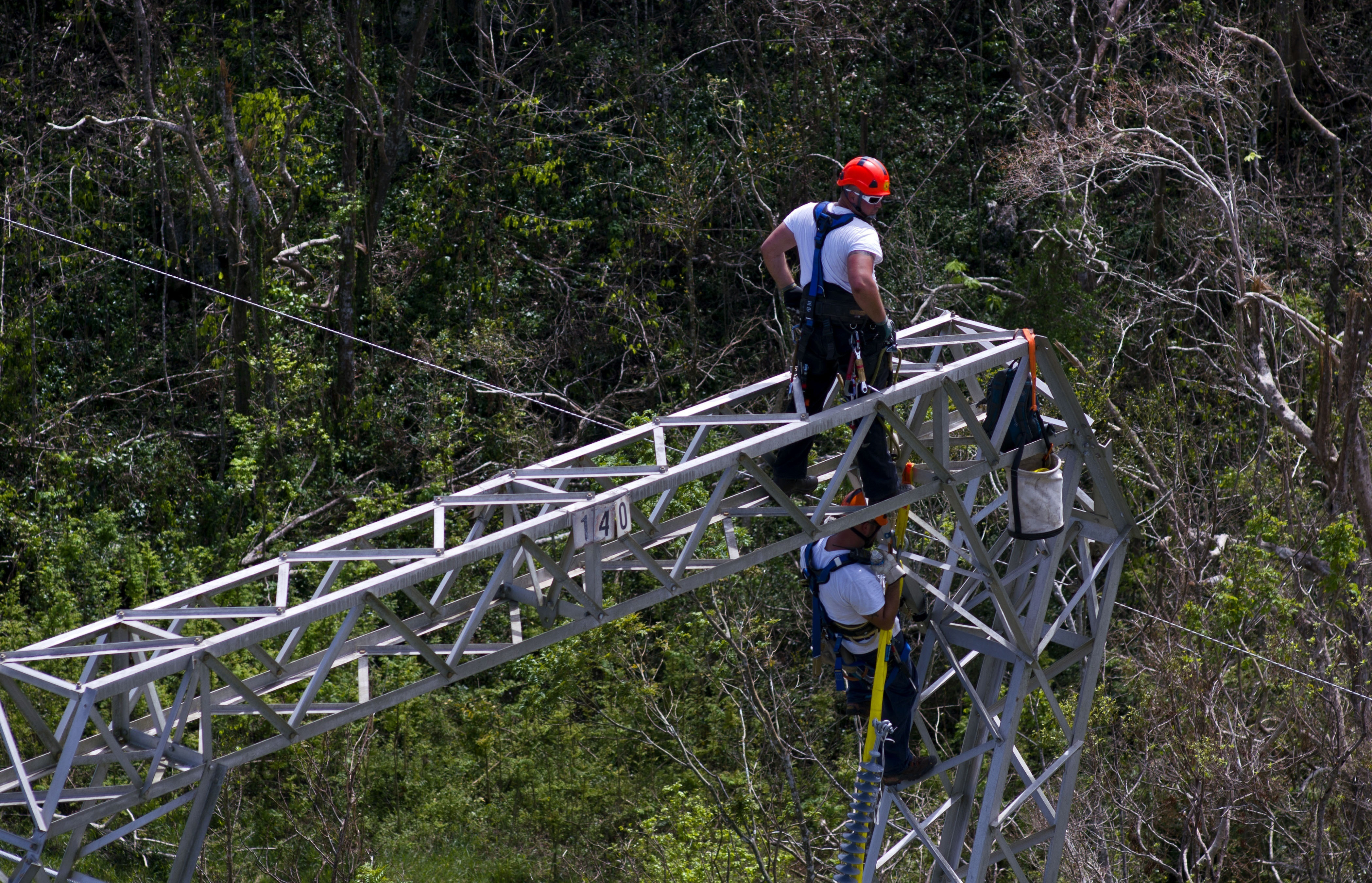 In this October 15, 2017 photo, Whitefish Energy Holdings workers restore power lines damaged by Hurricane Maria in Puerto Rico. CREDIT: AP Photo/Ramon Espinosa
