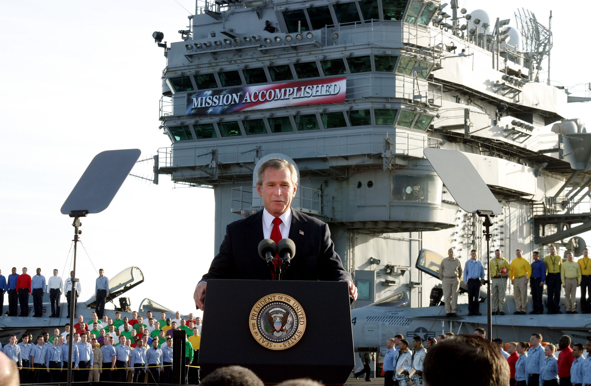 President Bush declared the end of major combat in Iraq as he speaks aboard the aircraft carrier USS Abraham Lincoln off the California coast, in this May 1, 2003 file photo. U.S. troops remain in Iraq 14 years on. CREDIT: J. Scott Applewhite/AP Photo.
