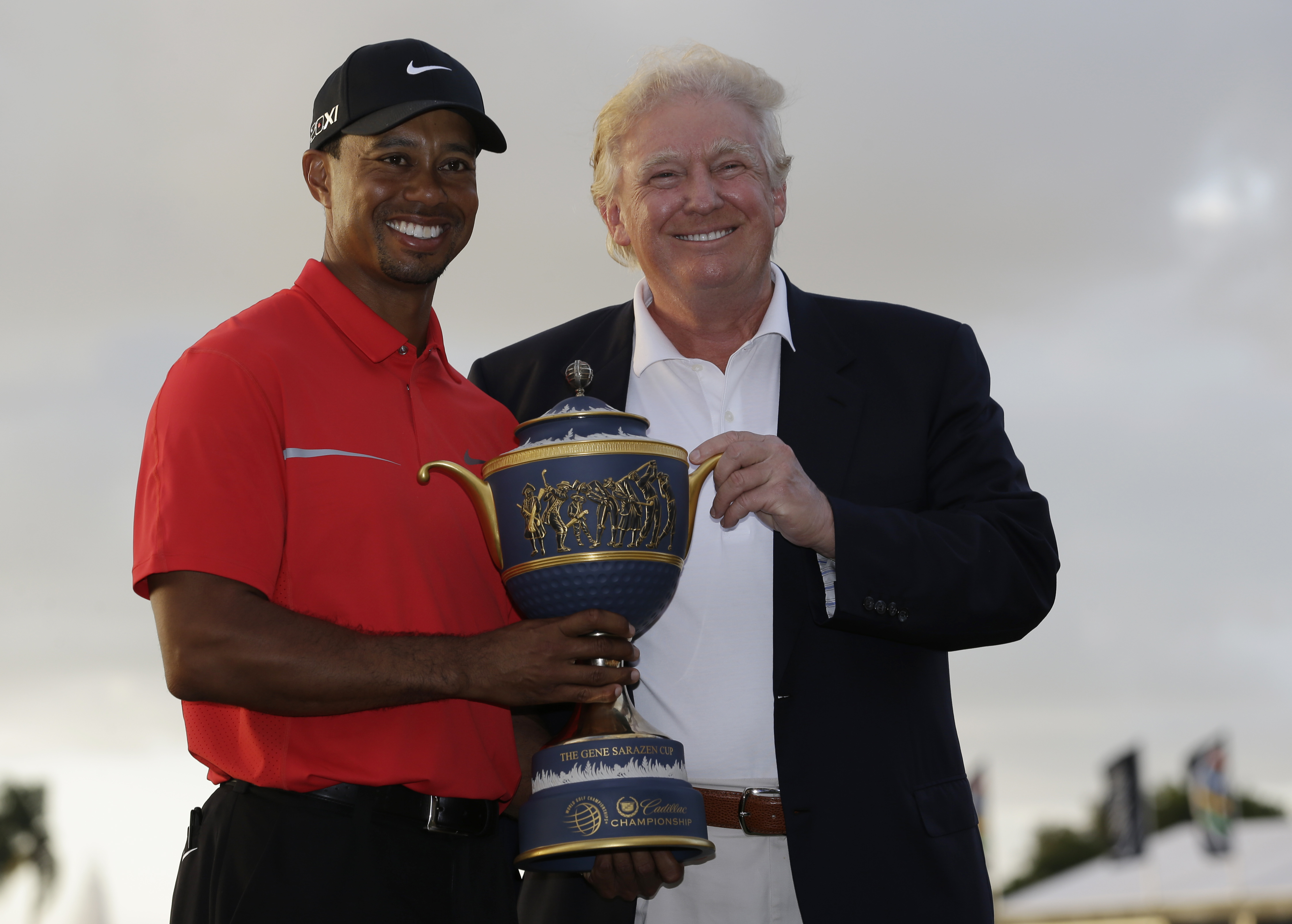 Tiger Woods stands with Donald Trump as he holds the Gene Serazen Cup for winning the Cadillac Championship golf tournament Sunday, March 10, 2013, in Doral, Fla. Woods won with a score 19-under-par 269. (AP Photo/Wilfredo Lee)