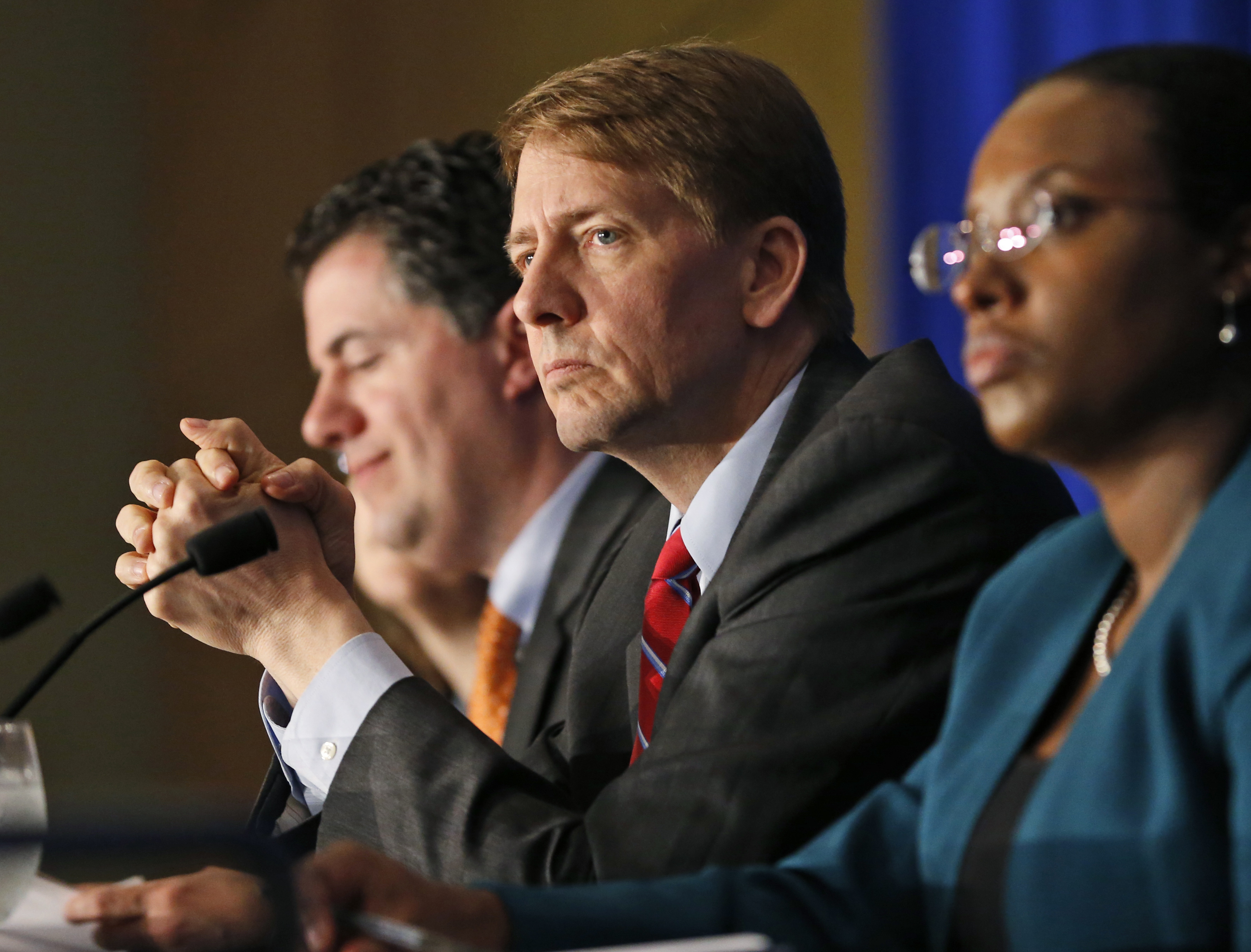 Consumer Financial Protection Bureau Director Richard Cordray, center, announced his intent to step down this month. CREDIT: AP Photo/Steve Helber, File