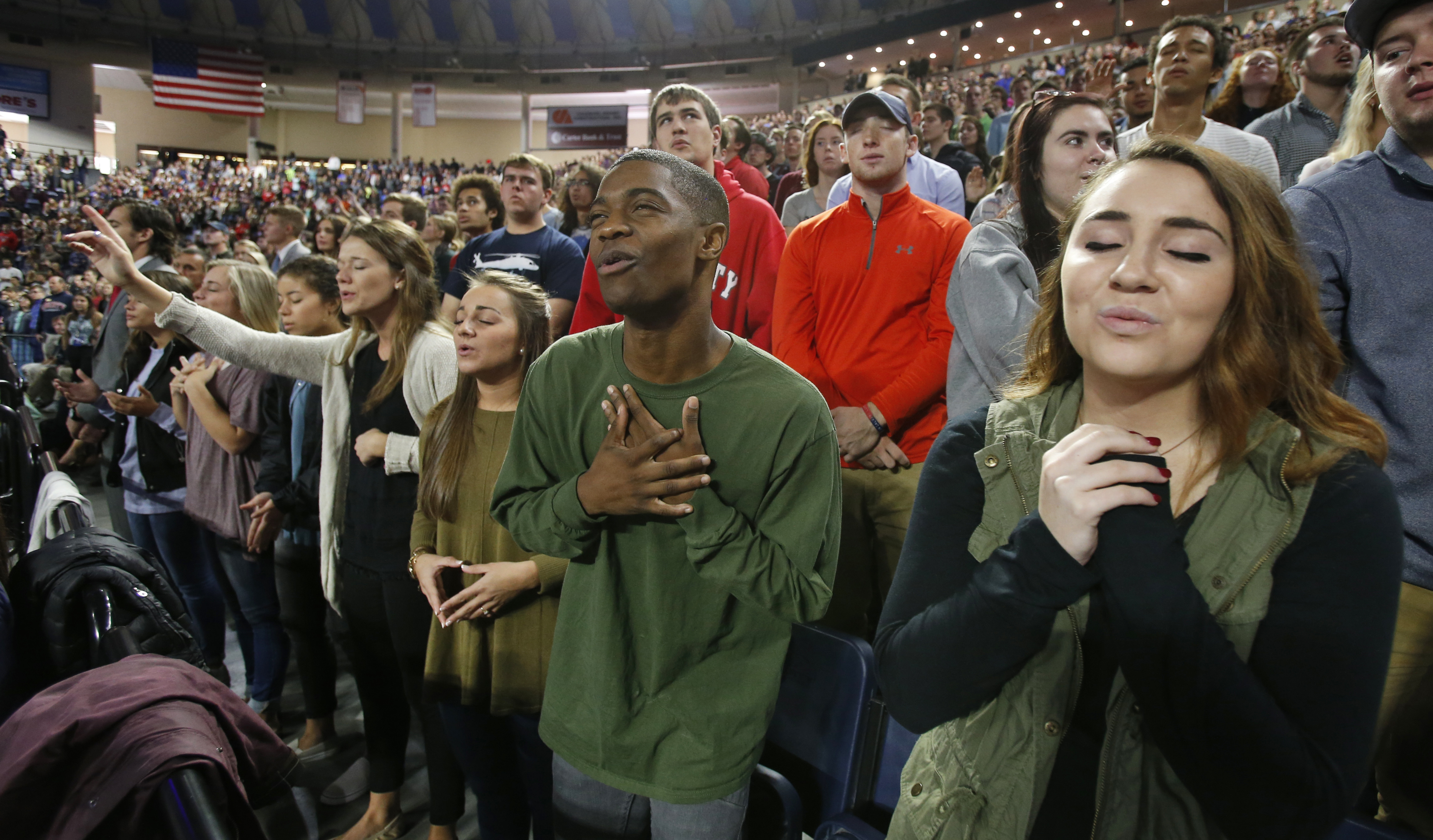Liberty University students sing and pray prior to a speech by Republican Vice Presidential candidate, Indiana Gov. Mike Pence, at Liberty University in Lynchburg, Va., Wednesday, Oct. 12, 2016. (CREDIT: AP Photo/Steve Helber)