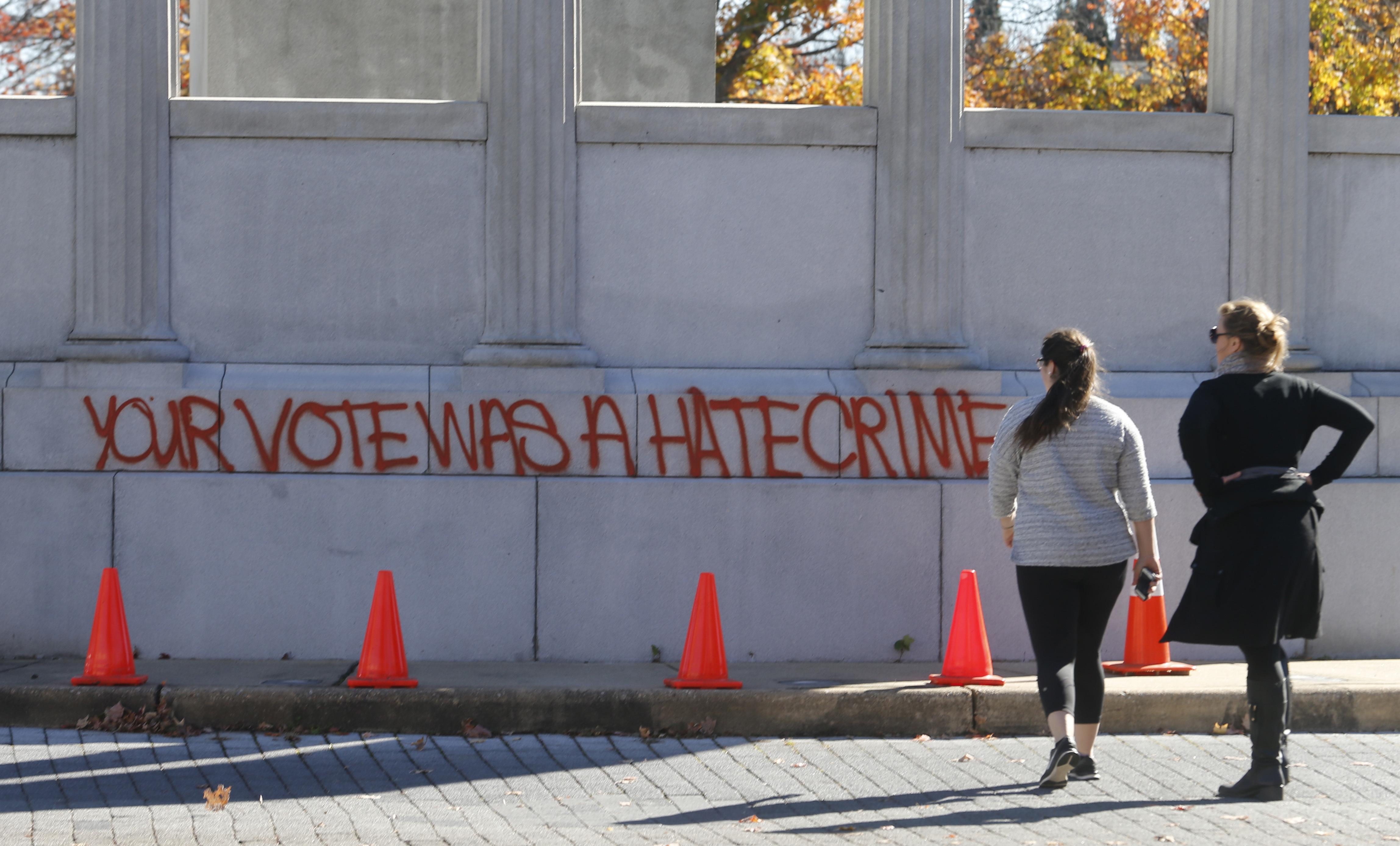 Pedestrians look at graffiti on the statue of Confederate President Jefferson Davis in Richmond, Virginia, Nov. 10, 2016. (CREDIT: AP Photo/Steve Helber)