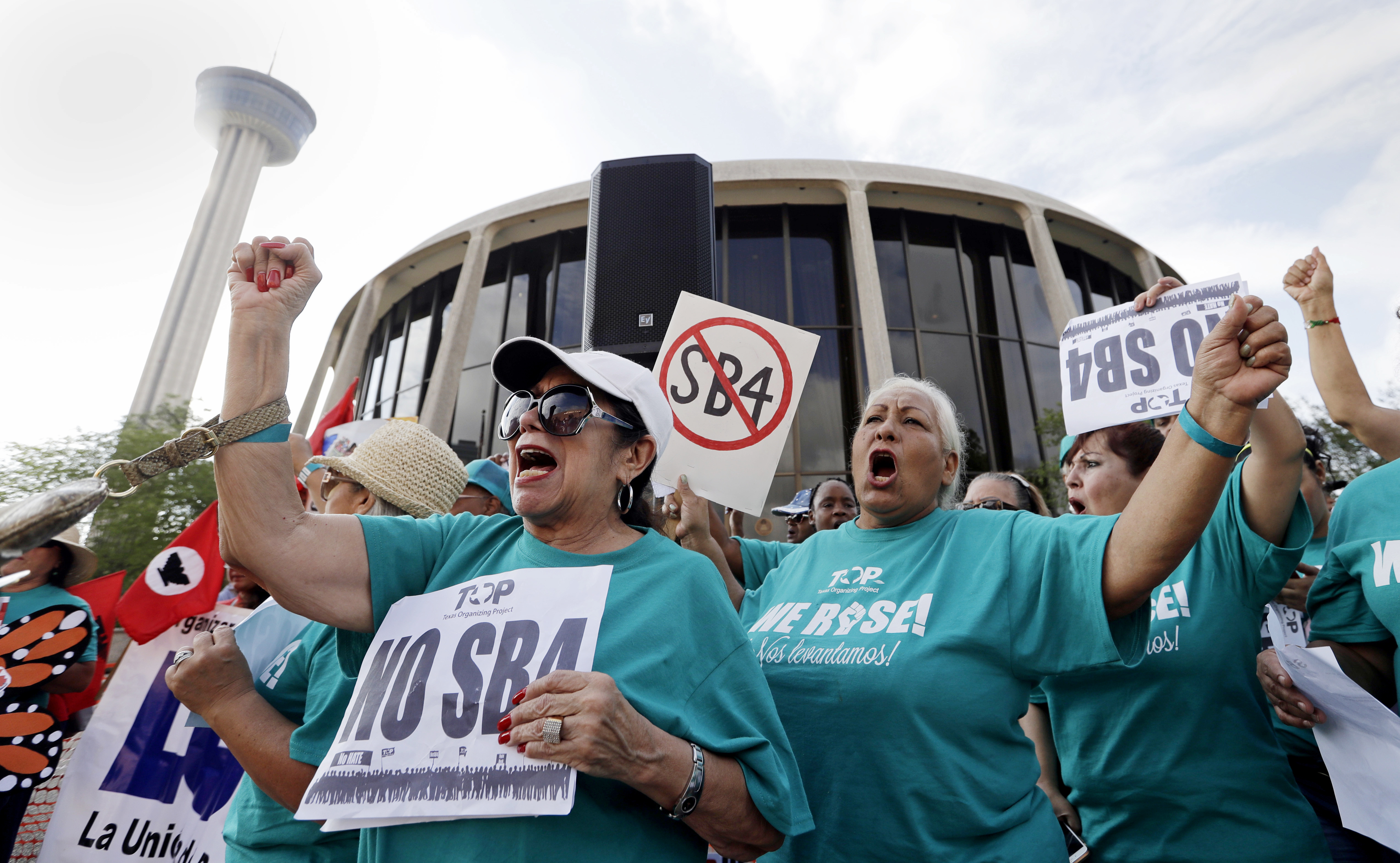 Lydia Balderas, left, and Merced Leyua, right, join others as they protest against a new sanctuary cities bill outside the federal courthouse in San Antonio. CREDIT: AP Photo/Eric Gay, File