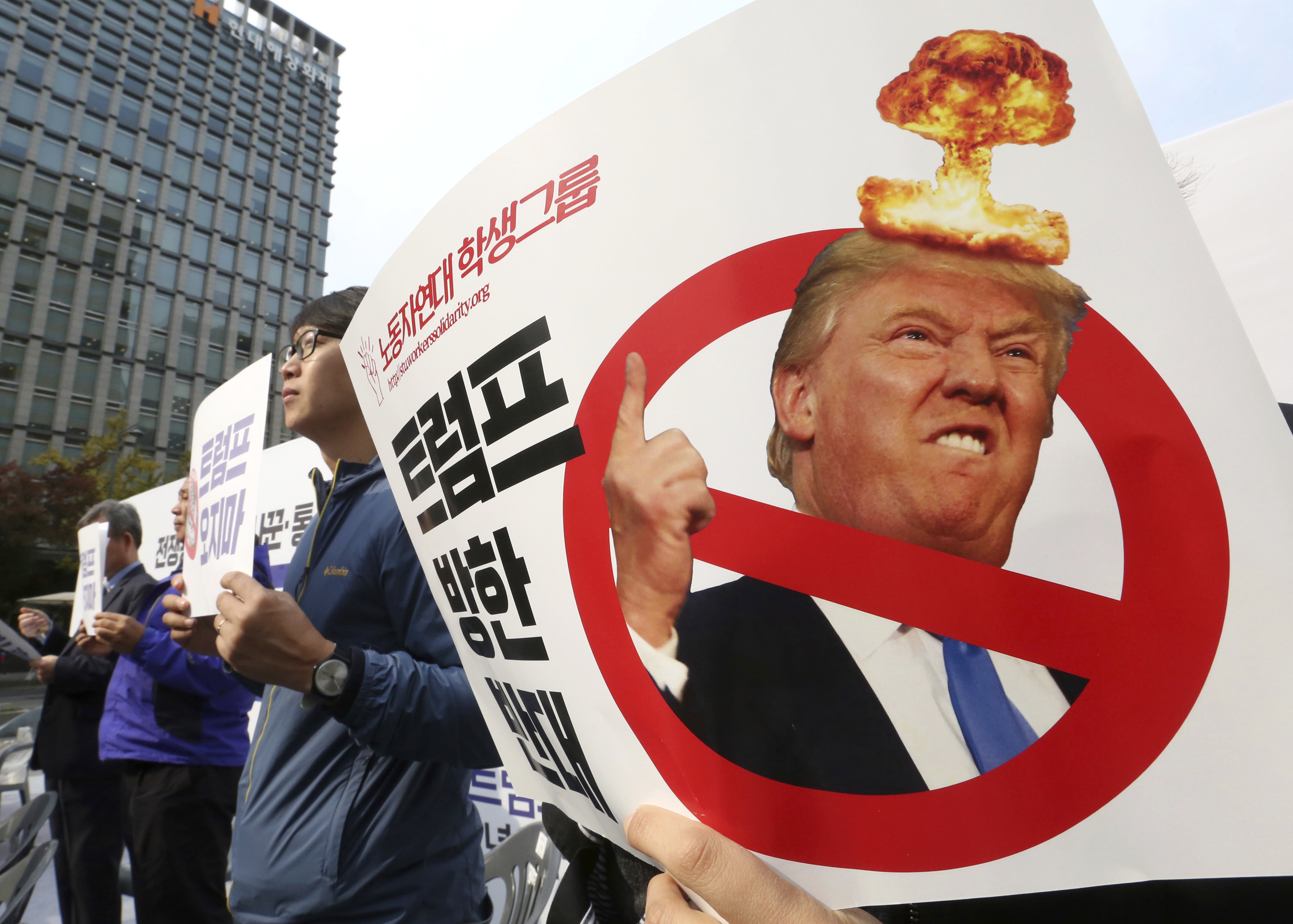 South Korean protesters stage a rally against a planned visit by U.S. President Donald Trump near the U.S. Embassy in Seoul, South Korea, Nov. 1, 2017. The signs held by the protesters read: "We oppose Trump's visit." (CREDIT: Ahn Young-joon/AP Photo)
