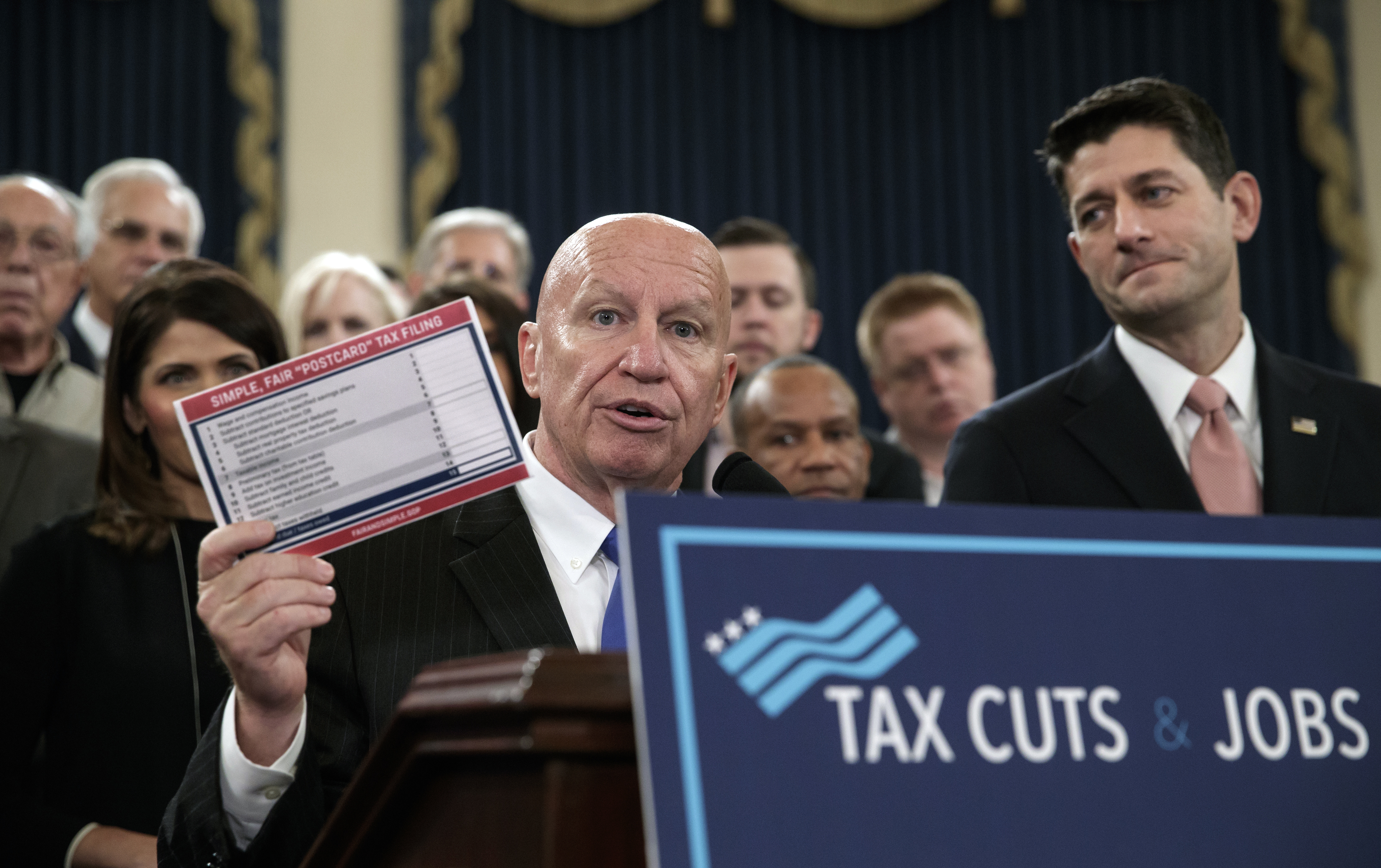 House Ways and Means Committee Chairman Kevin Brady, R-Texas, joined by Speaker of the House Paul Ryan, R-Wis., right, holds a proposed "postcard tax filing form" as they unveil the GOP's far-reaching tax overhaul, the first major revamp of the tax system in three decades, on Capitol Hill in Washington, Thursday, Nov. 2, 2017. (AP Photo/J. Scott Applewhite)