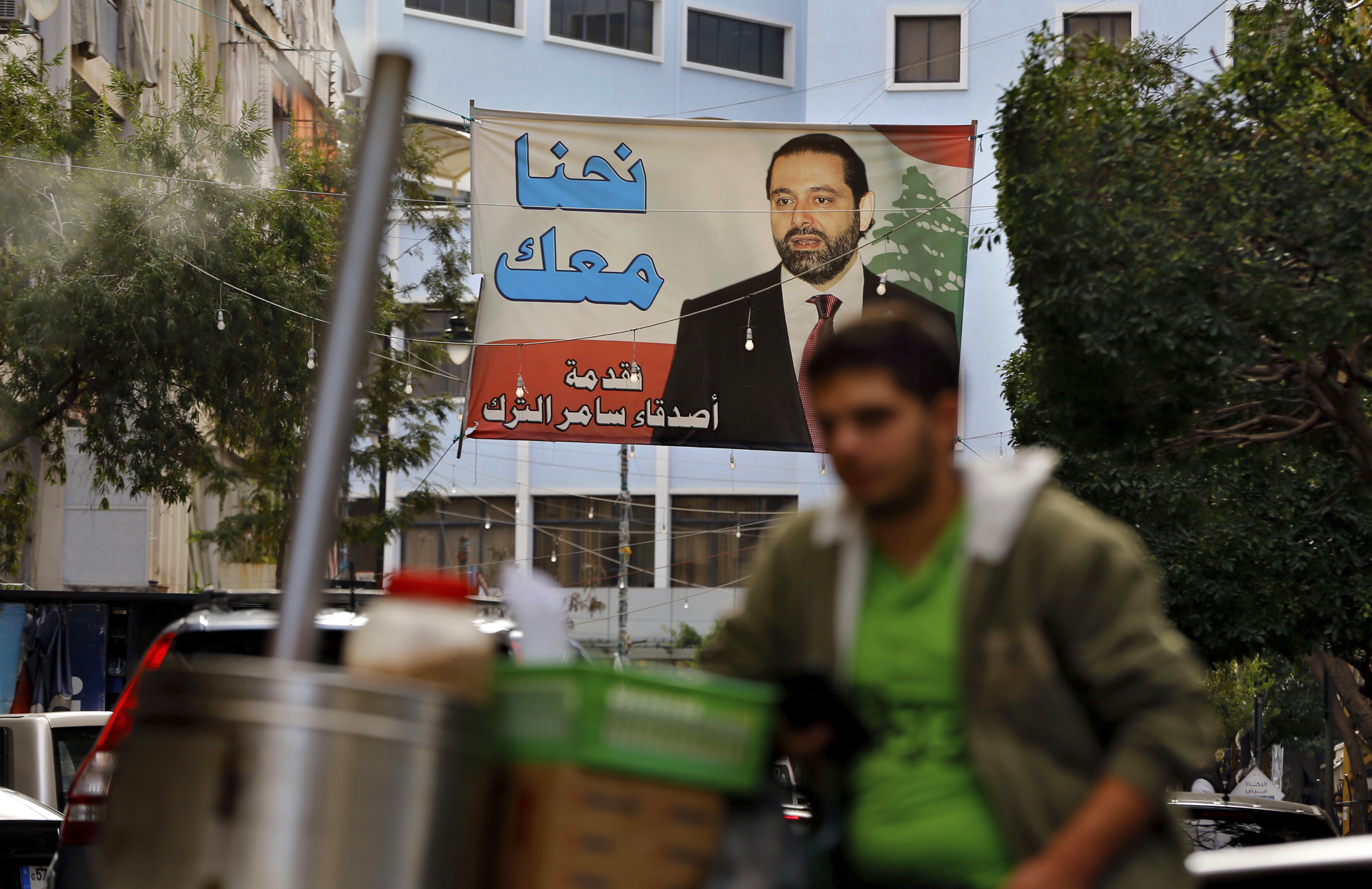 The abrupt resignation of Hariri was bizarre even by the often twisted standards of Lebanese politics: Saad Hariri made the announcement from the Saudi capital in a message on a Saudi-owned station. Stunned Lebanese are convinced Saudi Arabia, Hariri's longtime ally, forced him to take the step, which effectively wrecks the prime minister's delicate compromise government with Saudi nemesis and Iran ally Hezbollah. The poster in Arabic reads, "We are with you." CREDIT: Bilal Hussein/AP Photo.