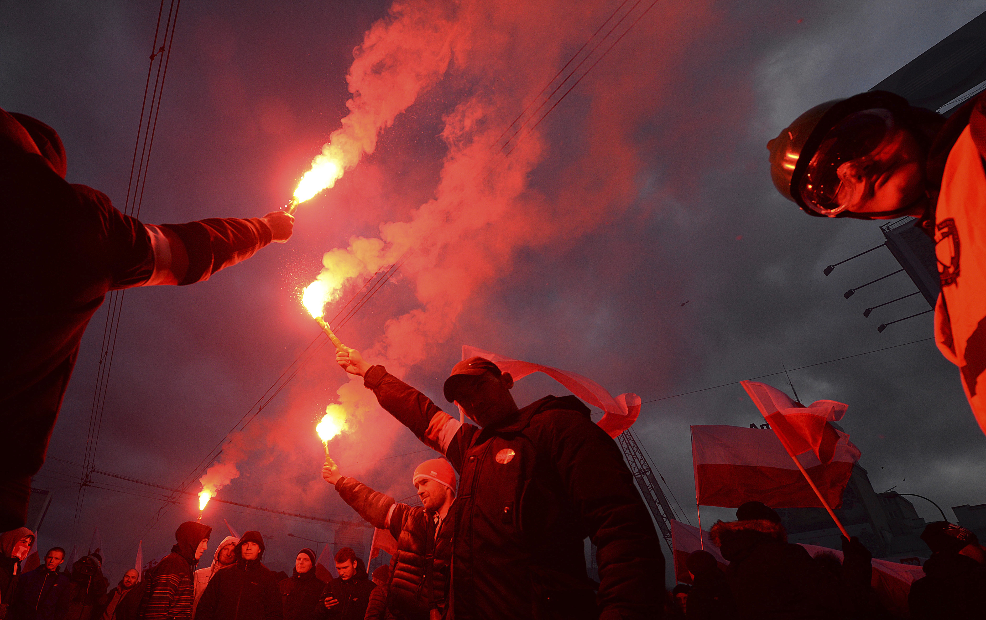 Demonstrators burn flares and wave Polish flags during the annual march to commemorate Poland's National Independence Day in Warsaw, Poland, Saturday, Nov. 11, 2017. CREDIT: AP Photo/Czarek Sokolowski
