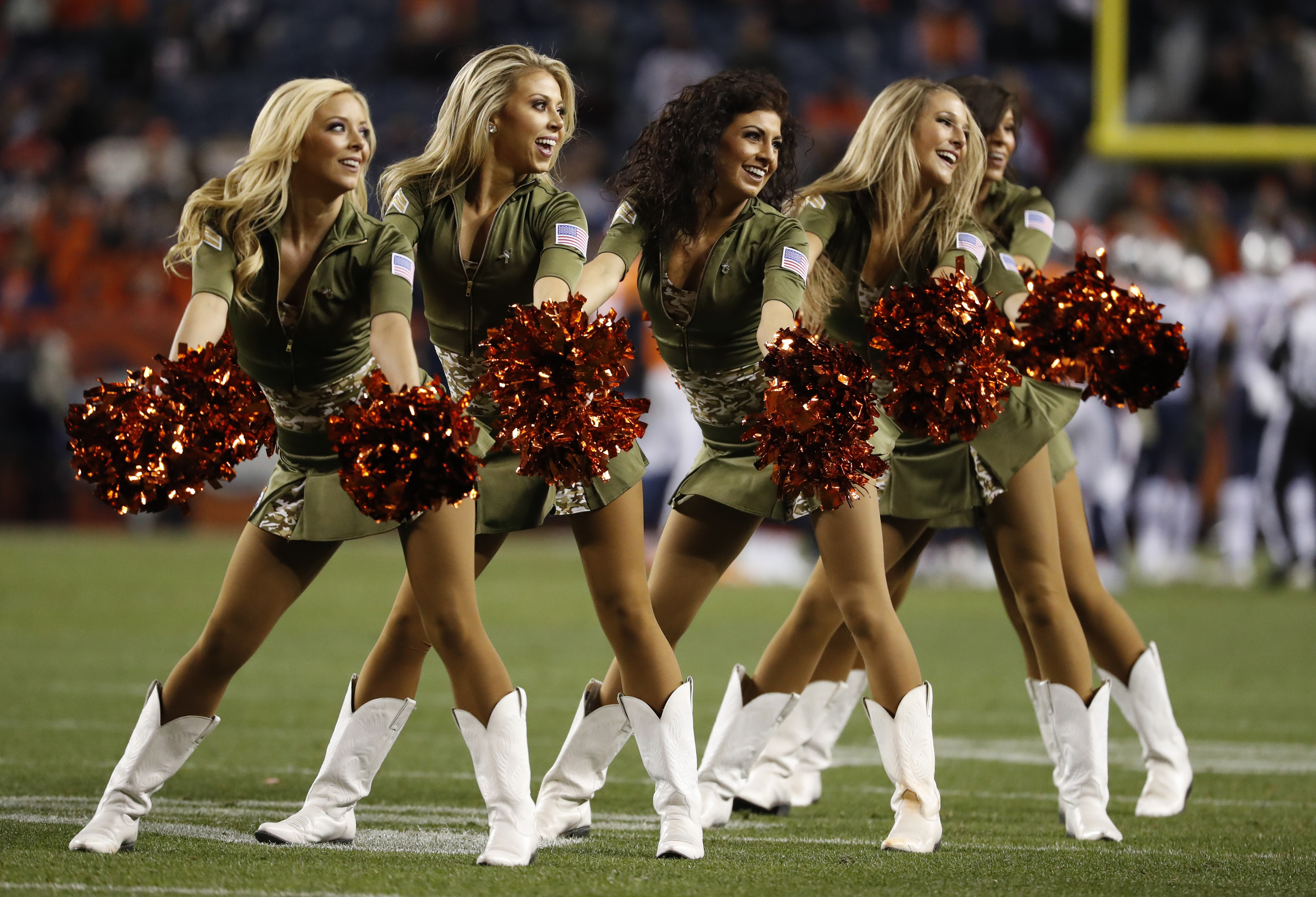 The Denver Broncos cheerleaders wear green to celebrate the NFL's Salute to Service prior to an NFL football game against the New England Patriots, Sunday, Nov. 12, 2017, in Denver. (AP Photo/David Zalubowski)