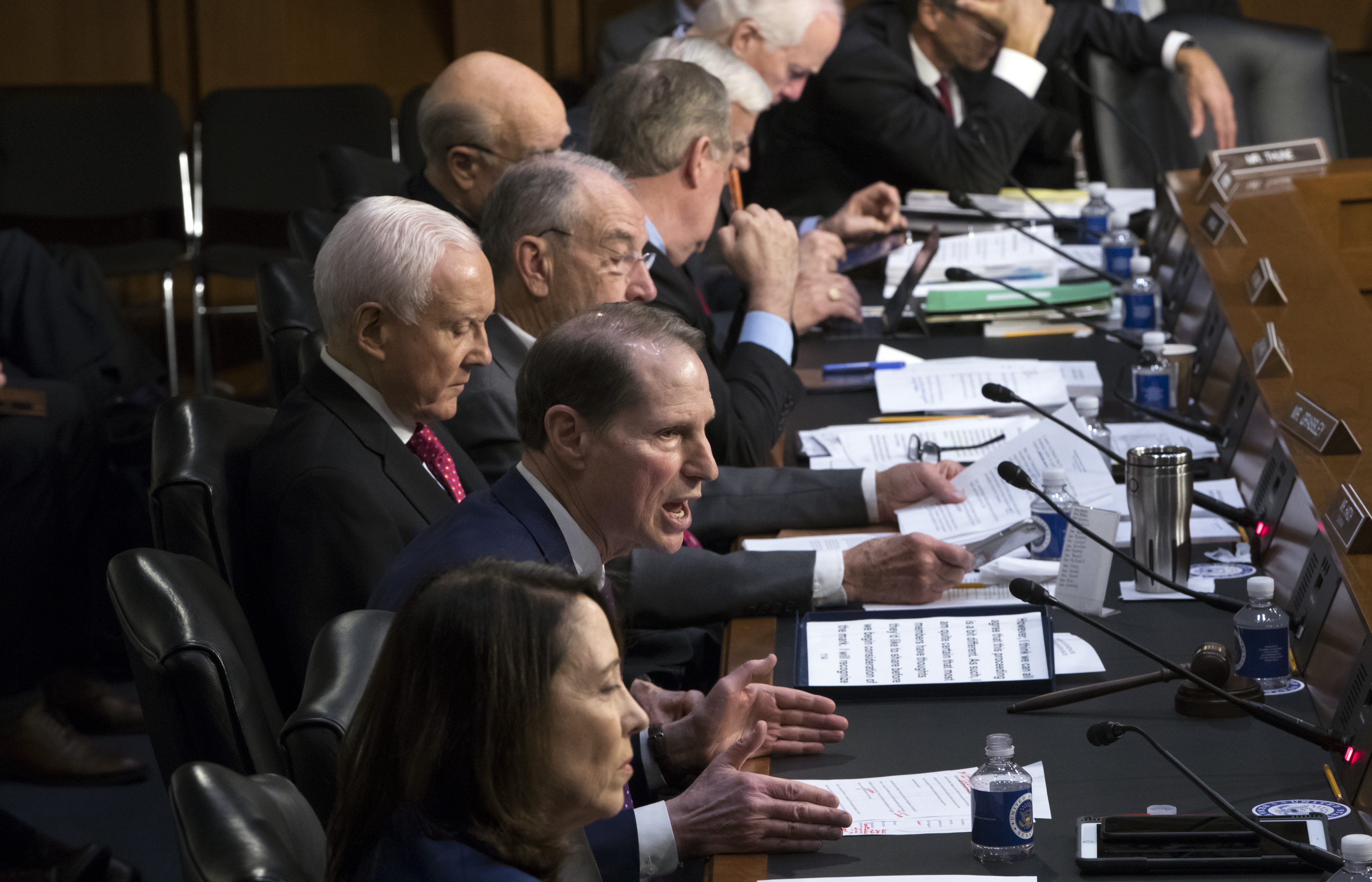Sen. Ron Wyden, D-Ore., center, the top Democrat on the Senate Finance Committee, criticizes the Republican tax reform plan while Chairman Orrin Hatch, R-Utah, left, and GOP members, top, listen to his opening statement as the panel begins work overhauling the nation's tax code, on Capitol Hill in Washington, Monday, Nov. 13, 2017. (AP Photo/J. Scott Applewhite)