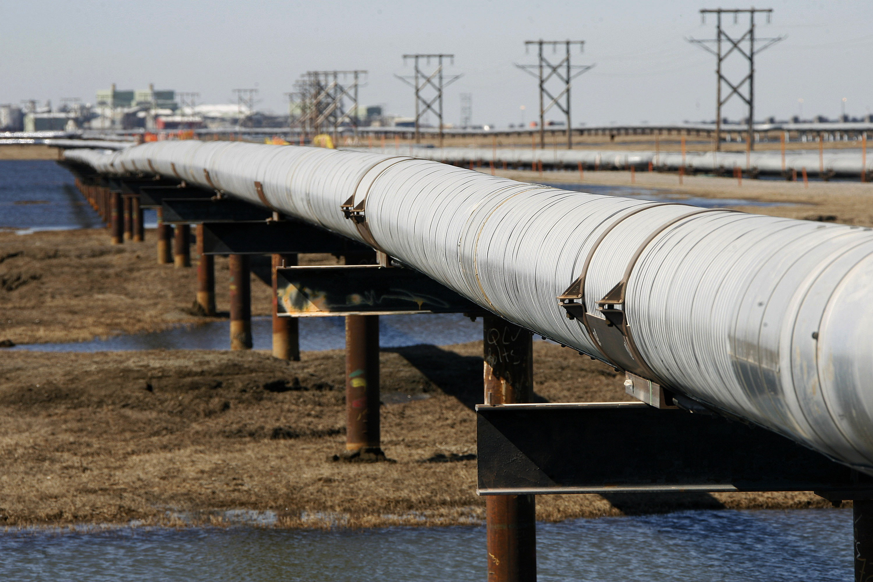 In this 2007 file photo, an oil transit pipeline runs across the tundra to flow station at the Prudhoe Bay oil field on Alaska's North Slope. CREDIT: AP Photo/Al Grillo