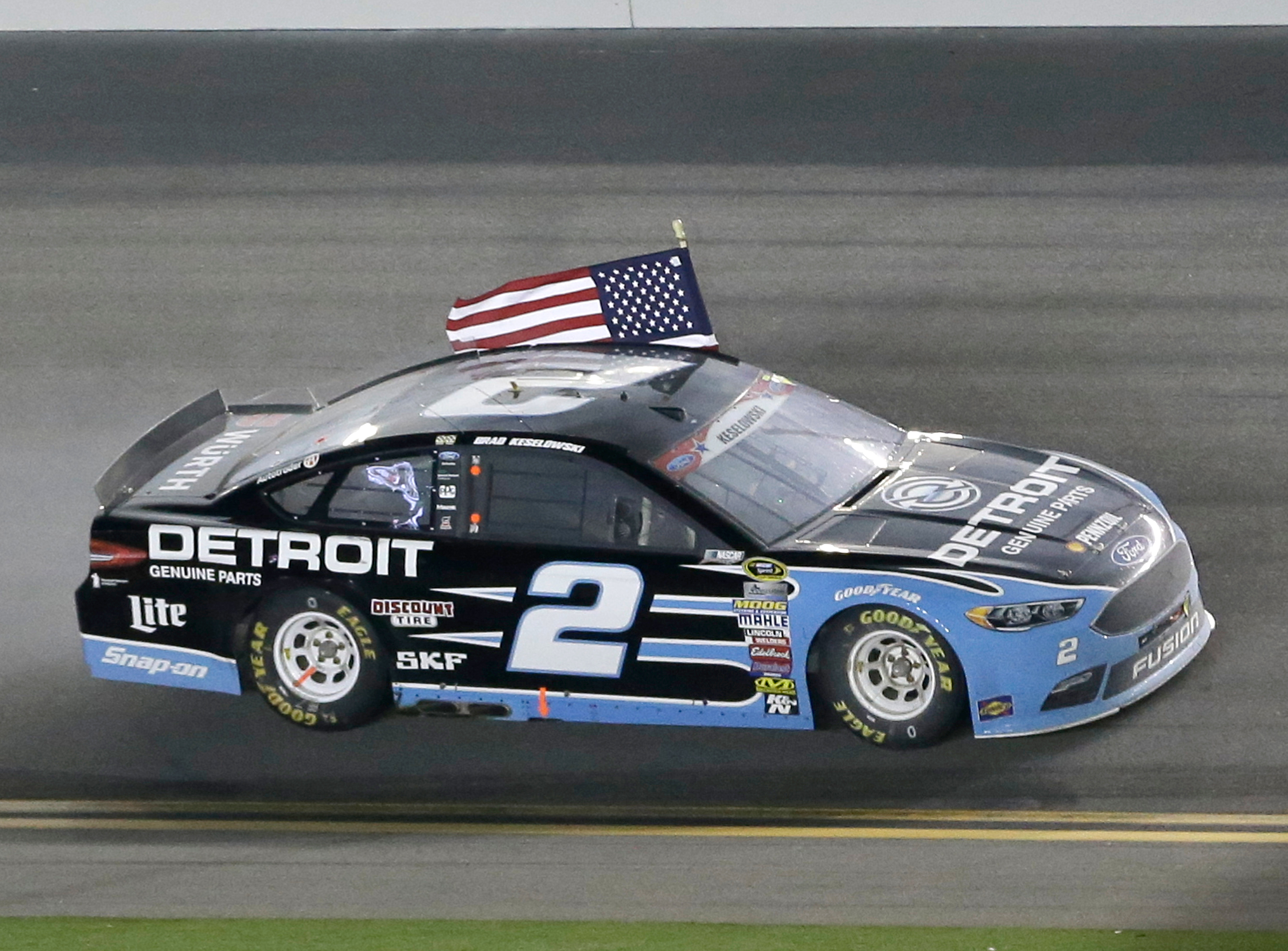 Brad Keselowski celebrates driving with an American flag after winning the NASCAR Sprint Cup Series auto race at Daytona International Speedway, Saturday, July 2, 2016, in Daytona Beach, Fla. (AP Photo/John Raoux)