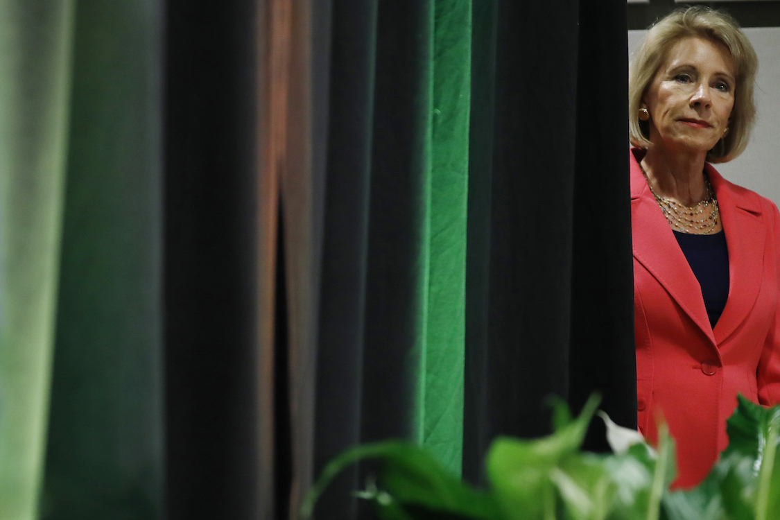 Education Secretary Betsy DeVos listens during her introduction to speak about proposed changes to Title IX, Thursday, Sept. 7, 2017, at George Mason University Arlington, Va., campus. CREDIT: AP/Jacquelyn Martin