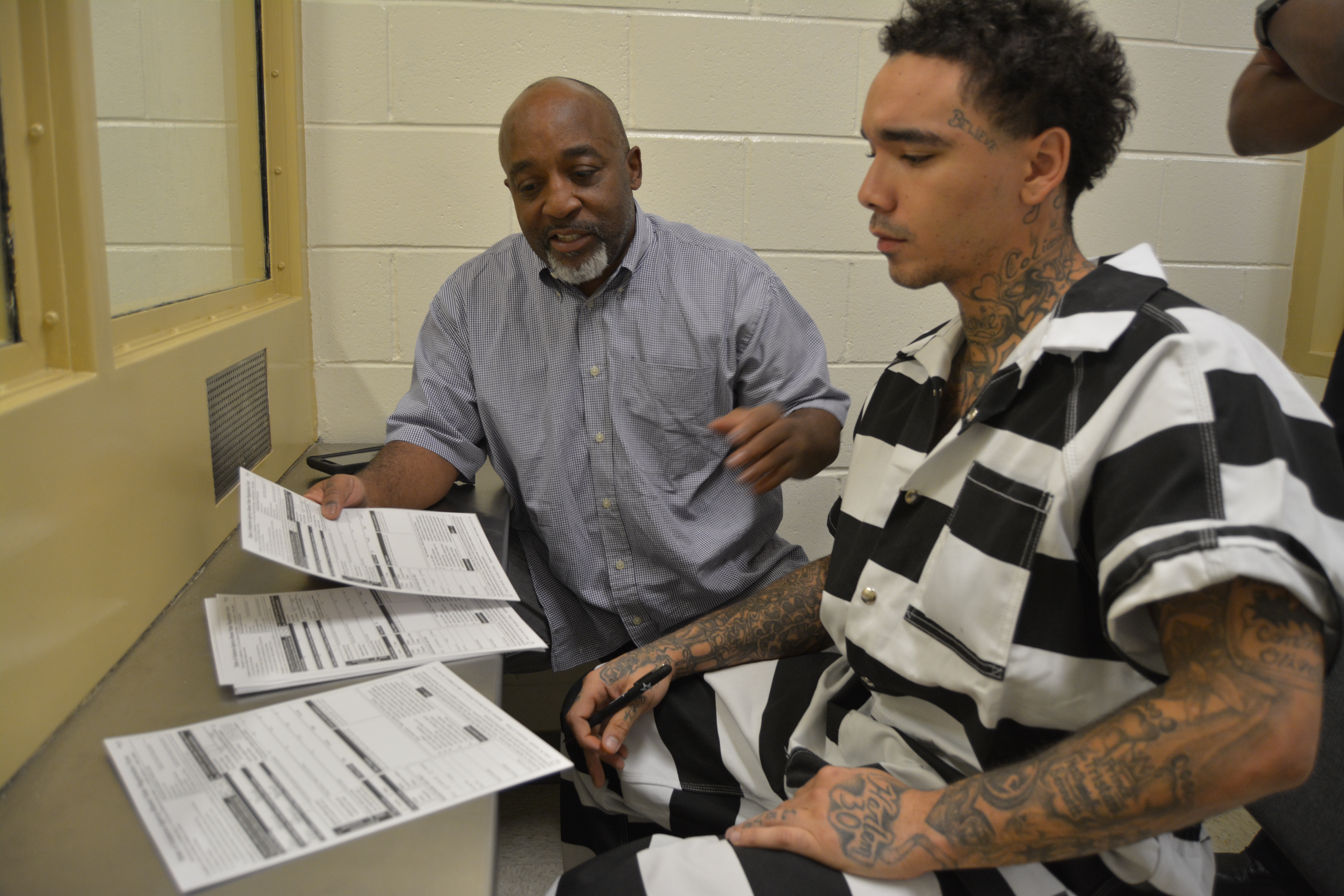 Glasgow helps Collin Bennett register to vote inside the Dothan City Jail. CREDIT: Kira Lerner