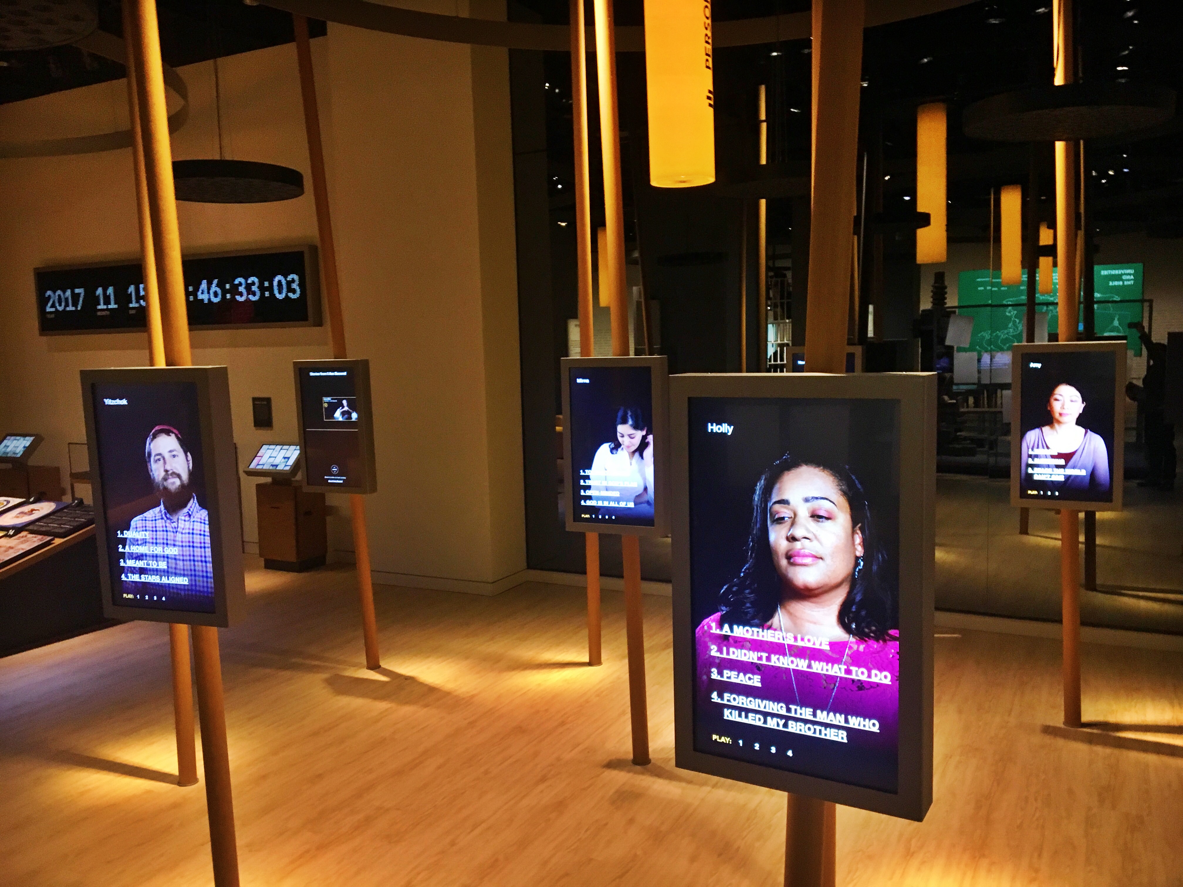 Screens with people describing how the Bible has impacted their lives. (CREDIT: Jack Jenkins/ThinkProgress)