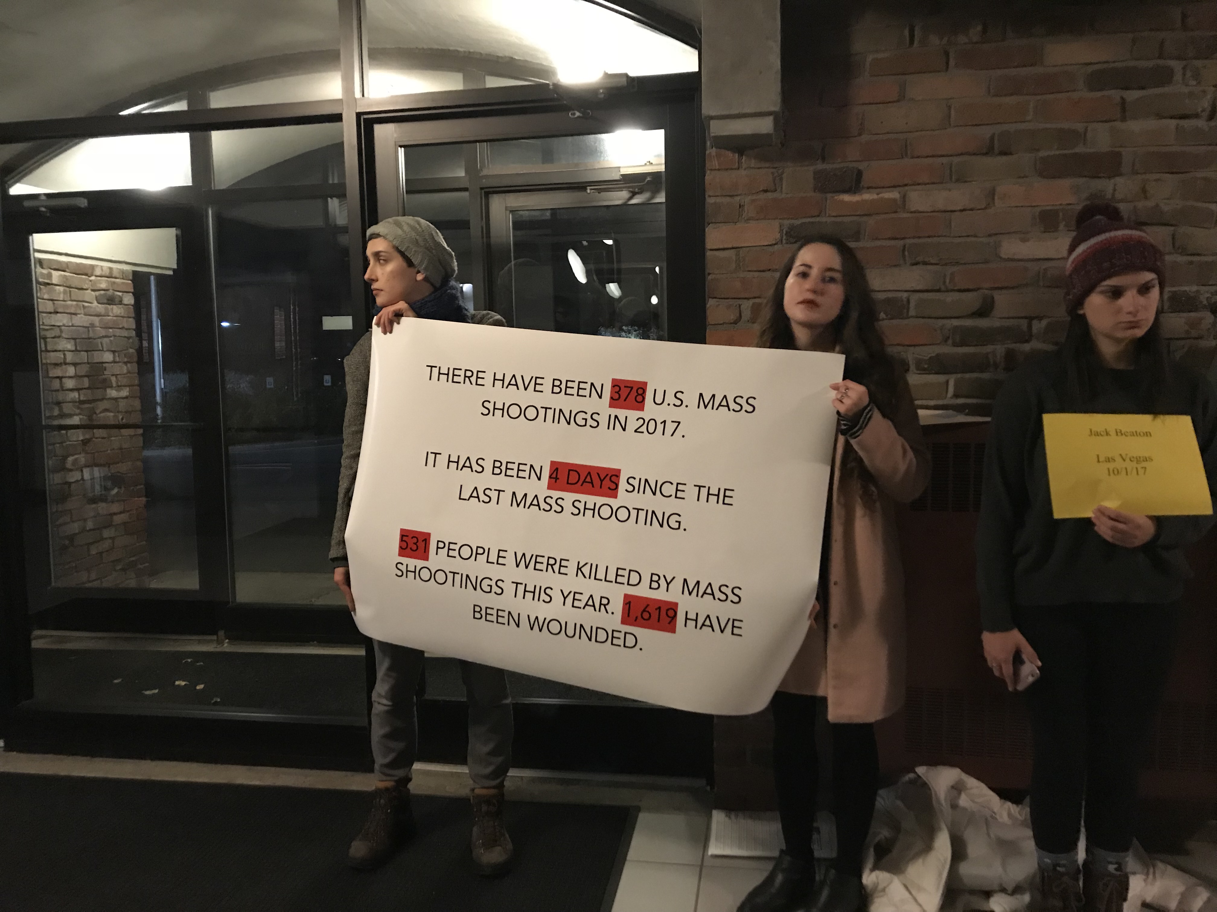 The Ithaca College students who organized the protest against Pratt hold up a sign detailing some statistics of gun violence in America (CREDIT: Evan Popp and Celisa Calacal)
