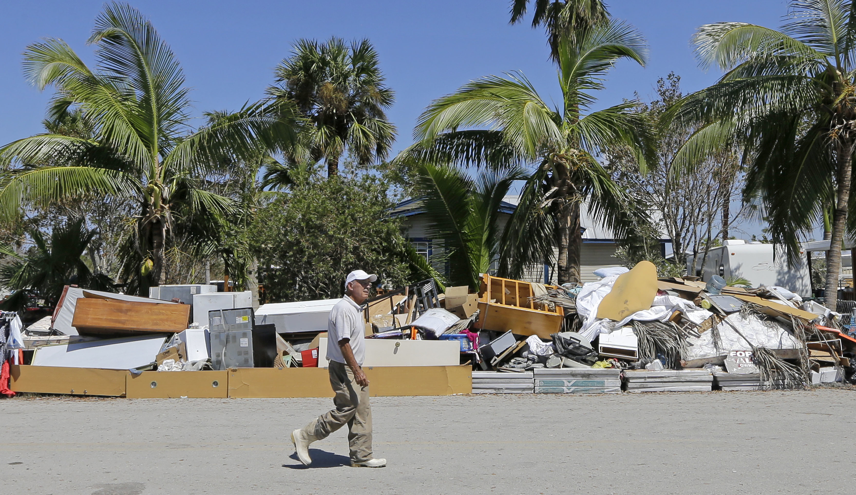 A resident walks by a pile of debris caused by a storm surge during Hurricane Irma on Sept. 18, 2017, in Everglades City, Florida. CREDIT: AP Photo/Alan Diaz